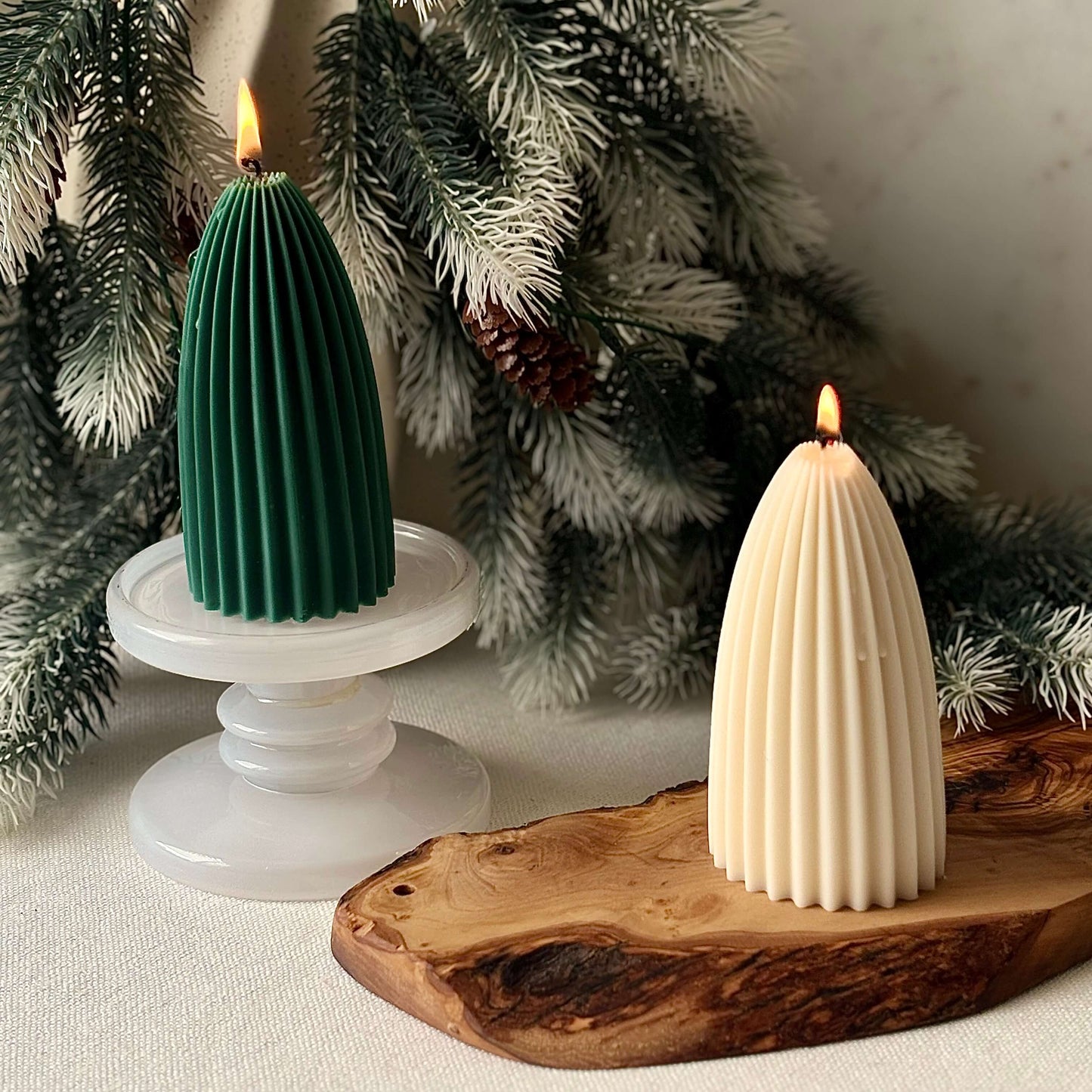 Pair of sculptural soy candles, green and beige, styled as ribbed Christmas trees for seasonal home décor