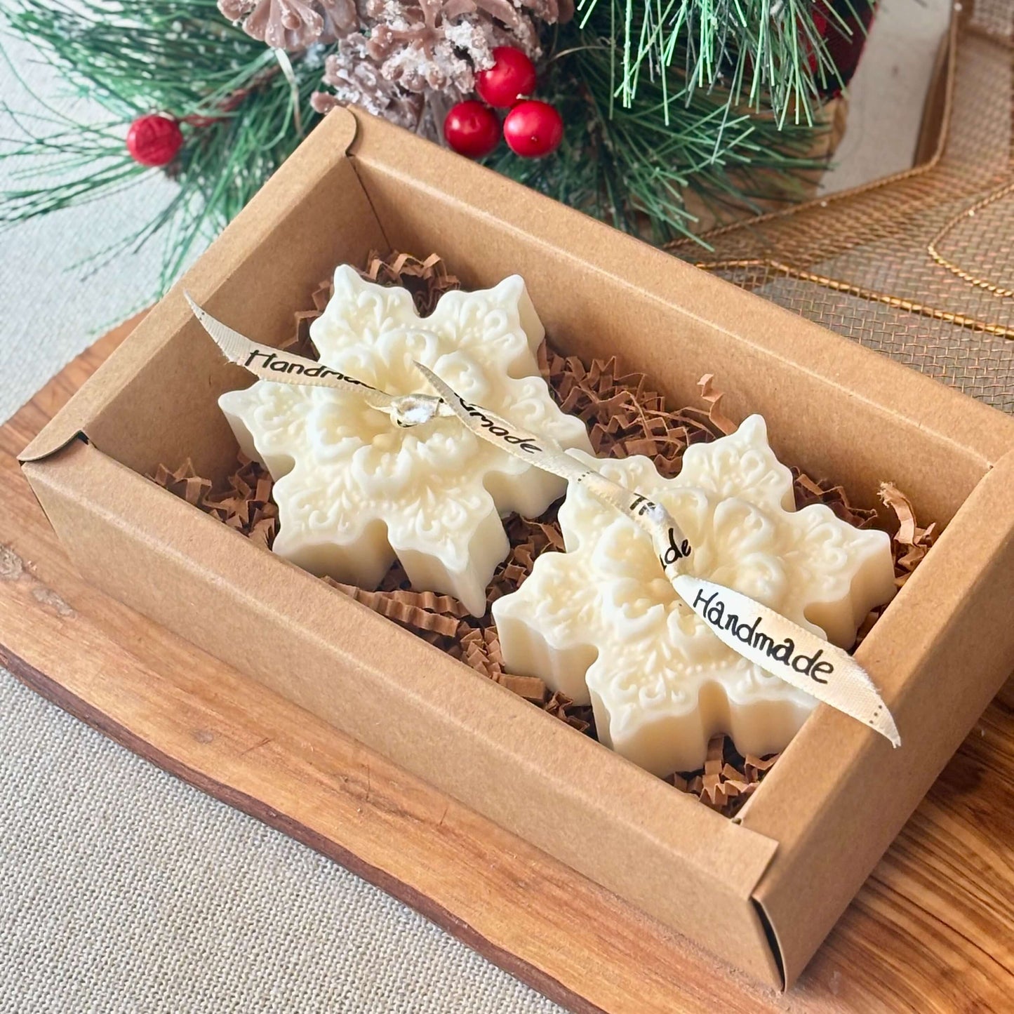 Two decorative snowflake soy wax candles in a festive brown box