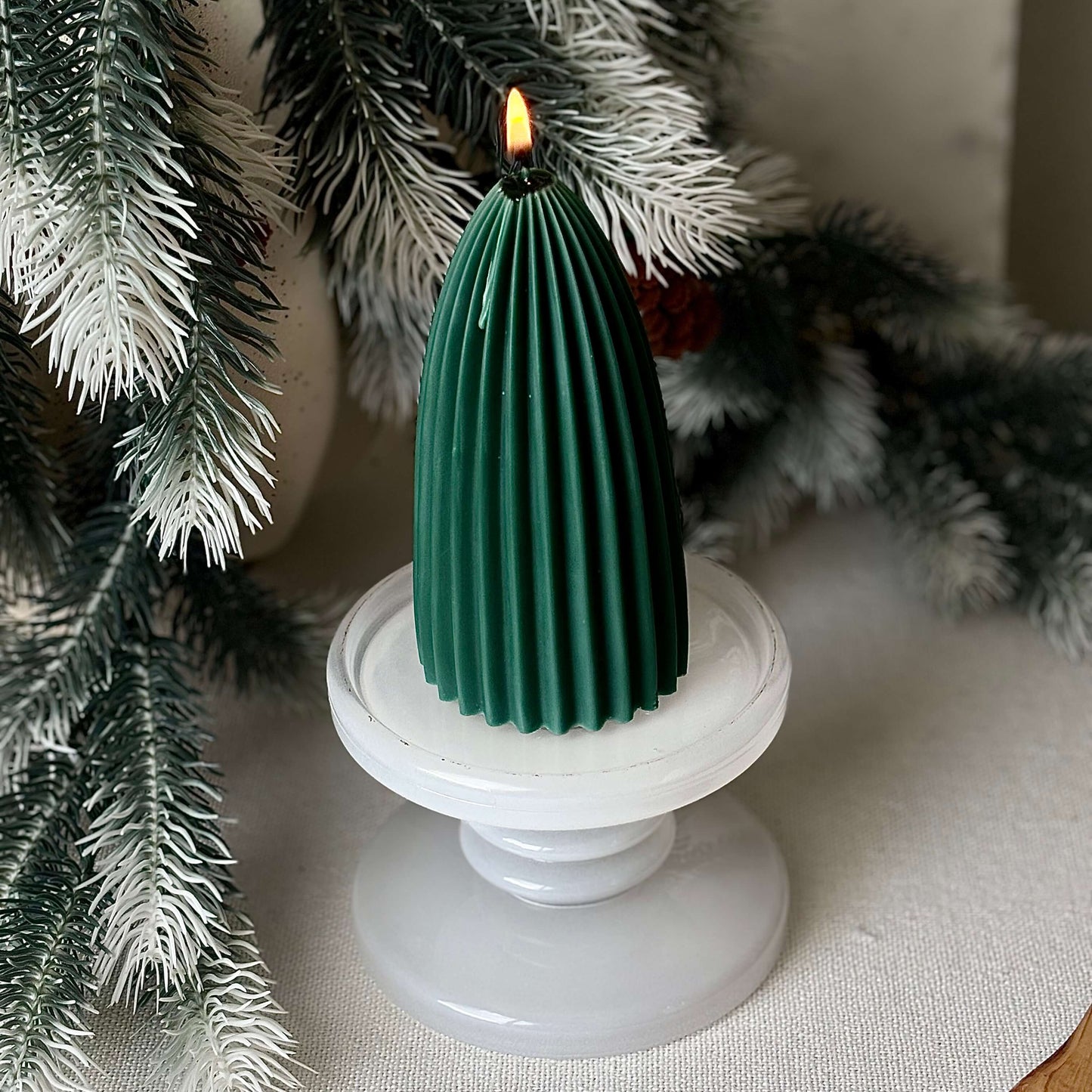 Sculptural green soy candle shaped like a Christmas tree, elegant holiday accent for winter décor