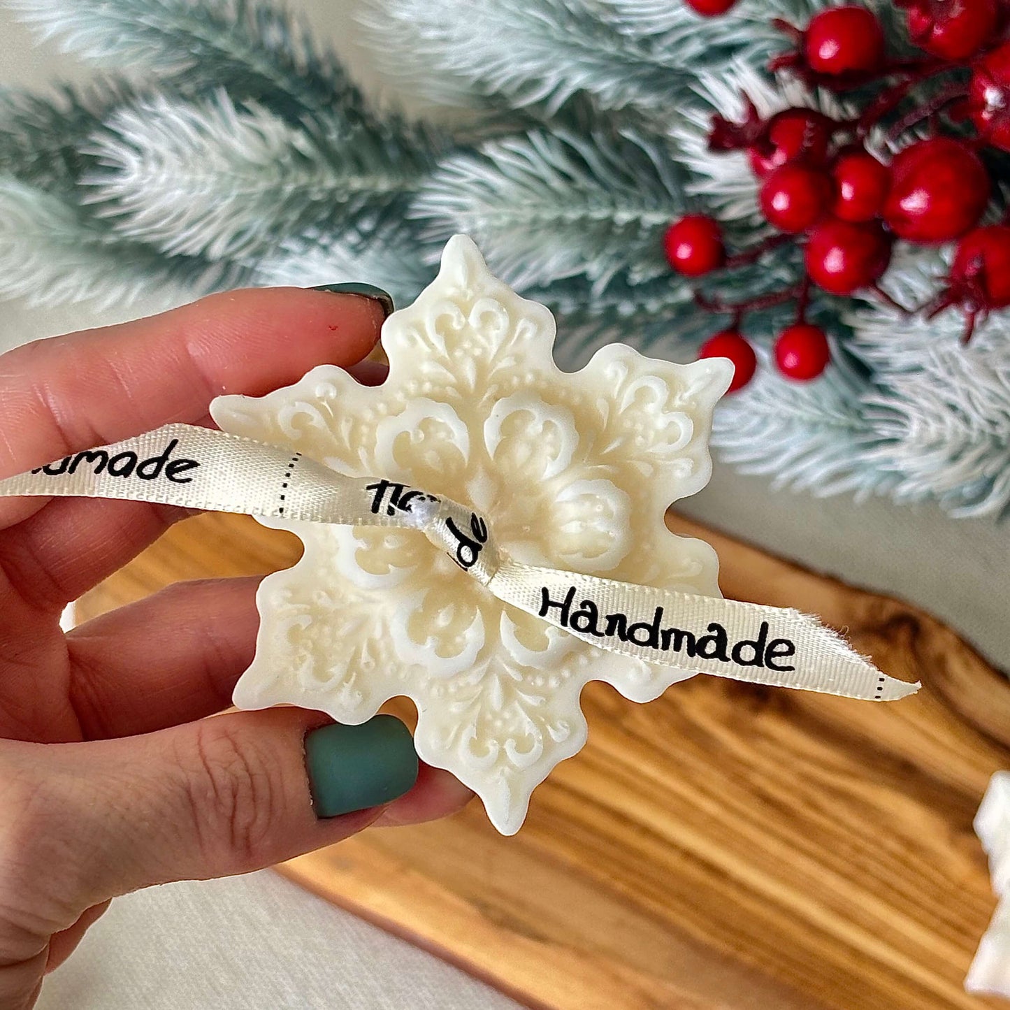 Decorative snowflake shaped candles with ribbon in Christmas themed packaging