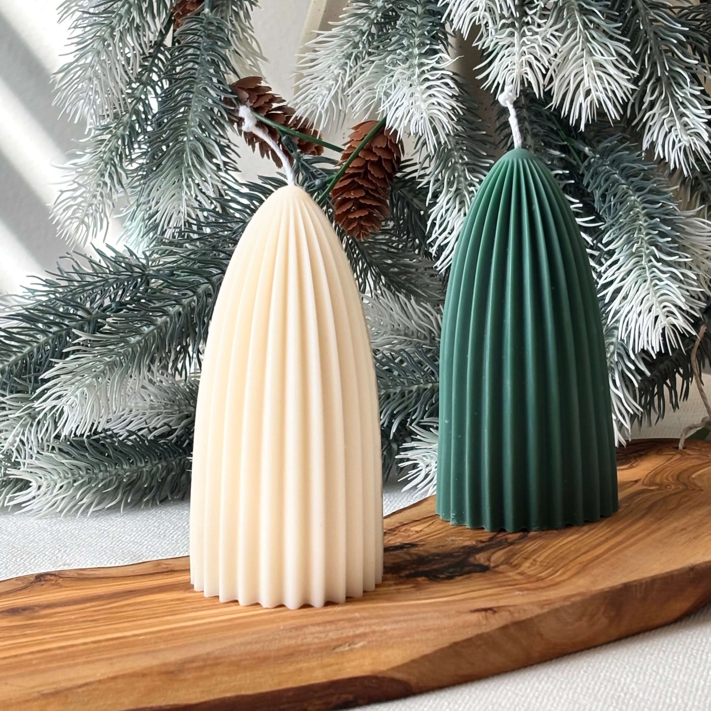 Two ribbed soy candles, beige and green, sculptural Christmas tree style on wooden holiday tray
