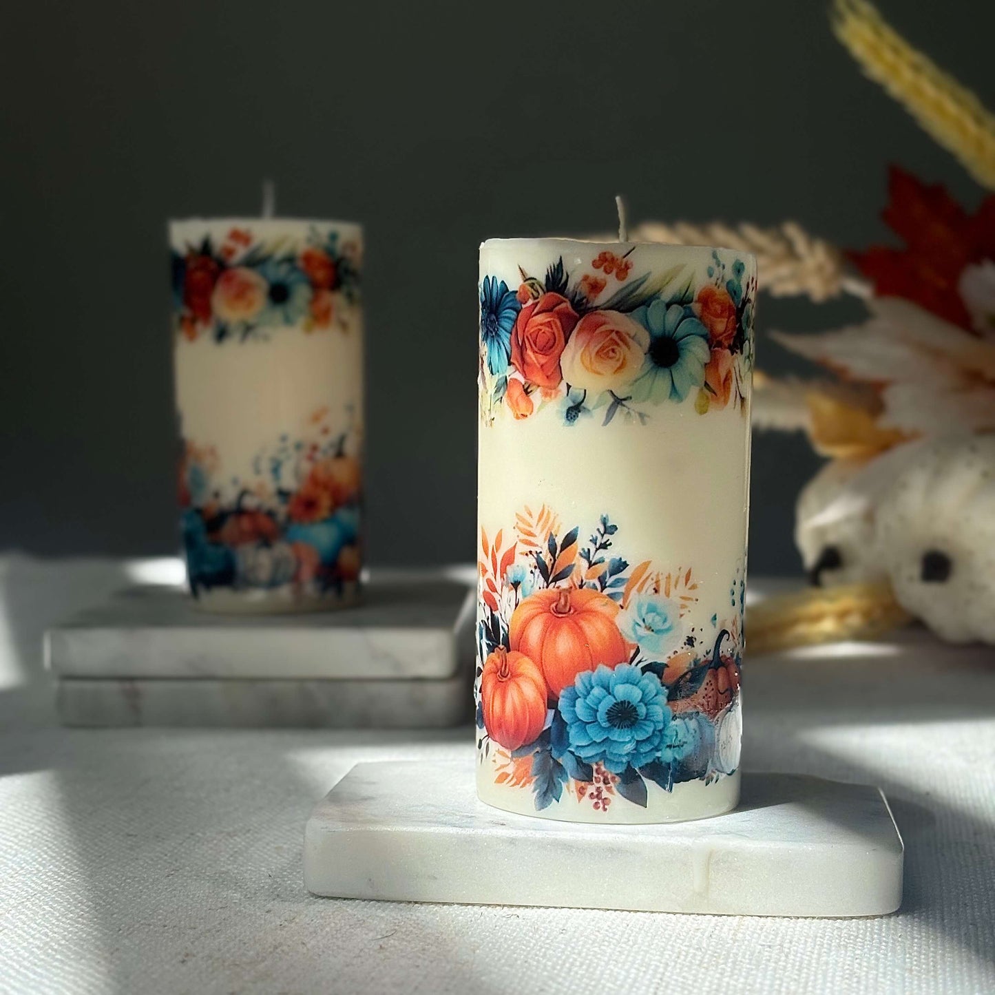 Autumn glossy pumpkin candle with floral design for seasonal home decor