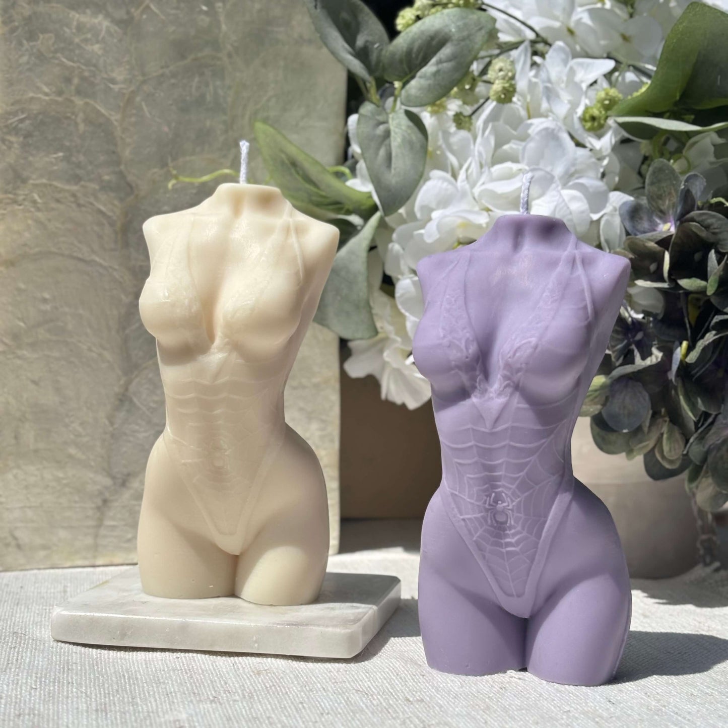Set of two female torso candles, beige and purple soy wax sculptures, handmade decorative candles with floral arrangement.