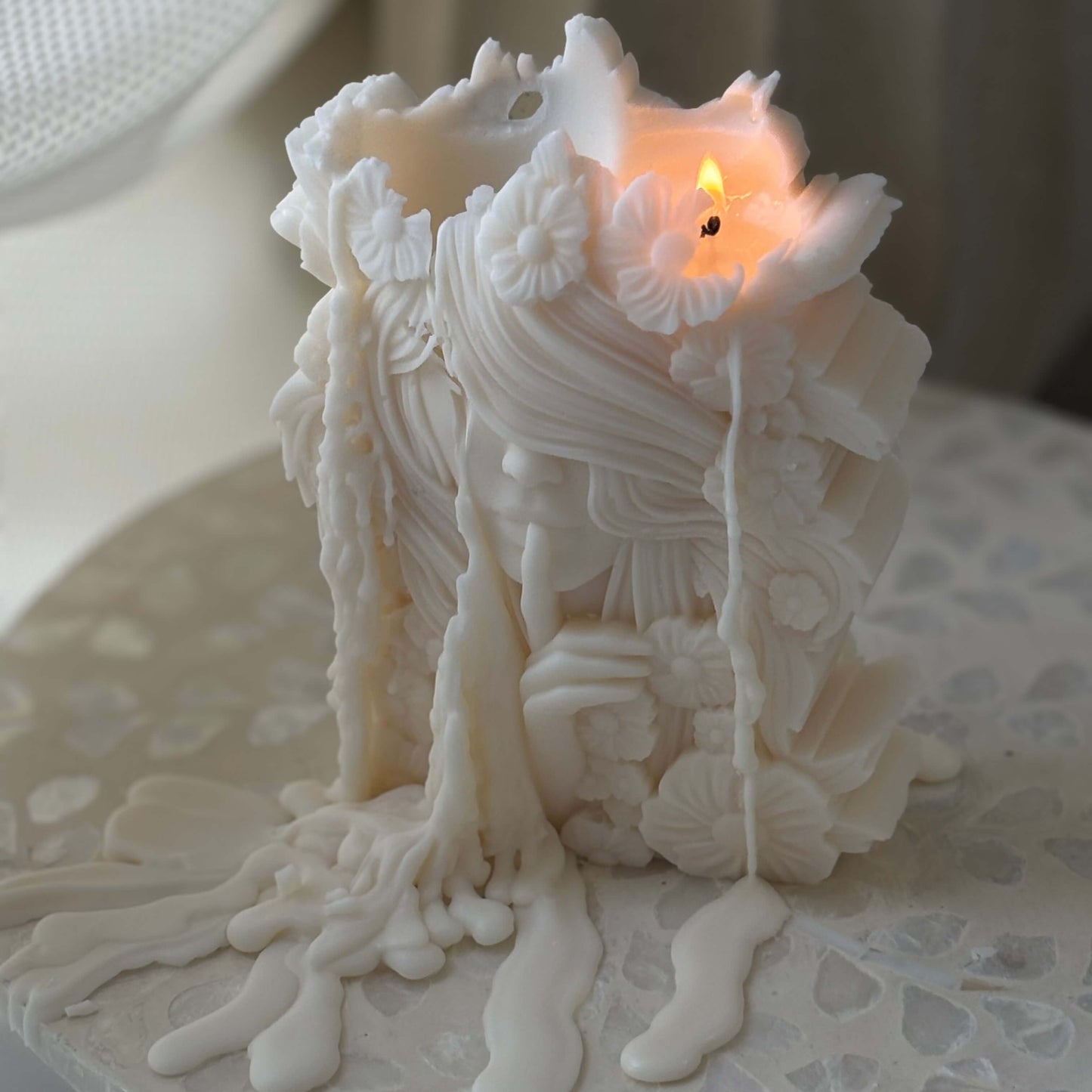 Lit flower goddess candle made of natural soy wax with floral sculpted details, burning beautifully as elegant decor for home or meditation space