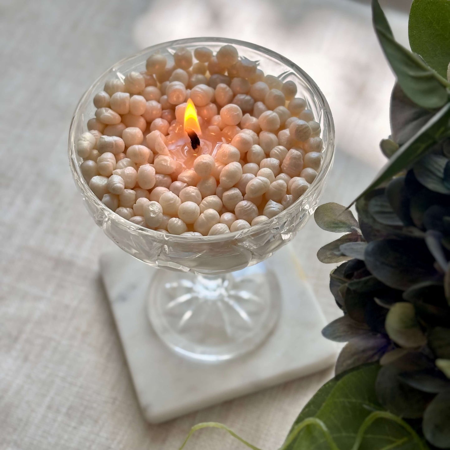 Lit pearl soy wax candle on marble coaster — cozy Thanksgiving table décor and holiday gift