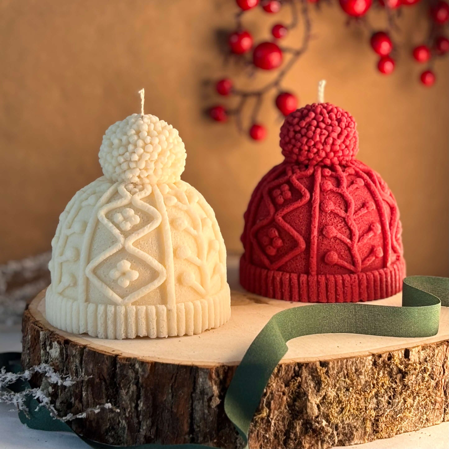 Red and white beanie candles placed on wood base with berries in the background, ideal for Christmas centerpiece or holiday coffee table styling
