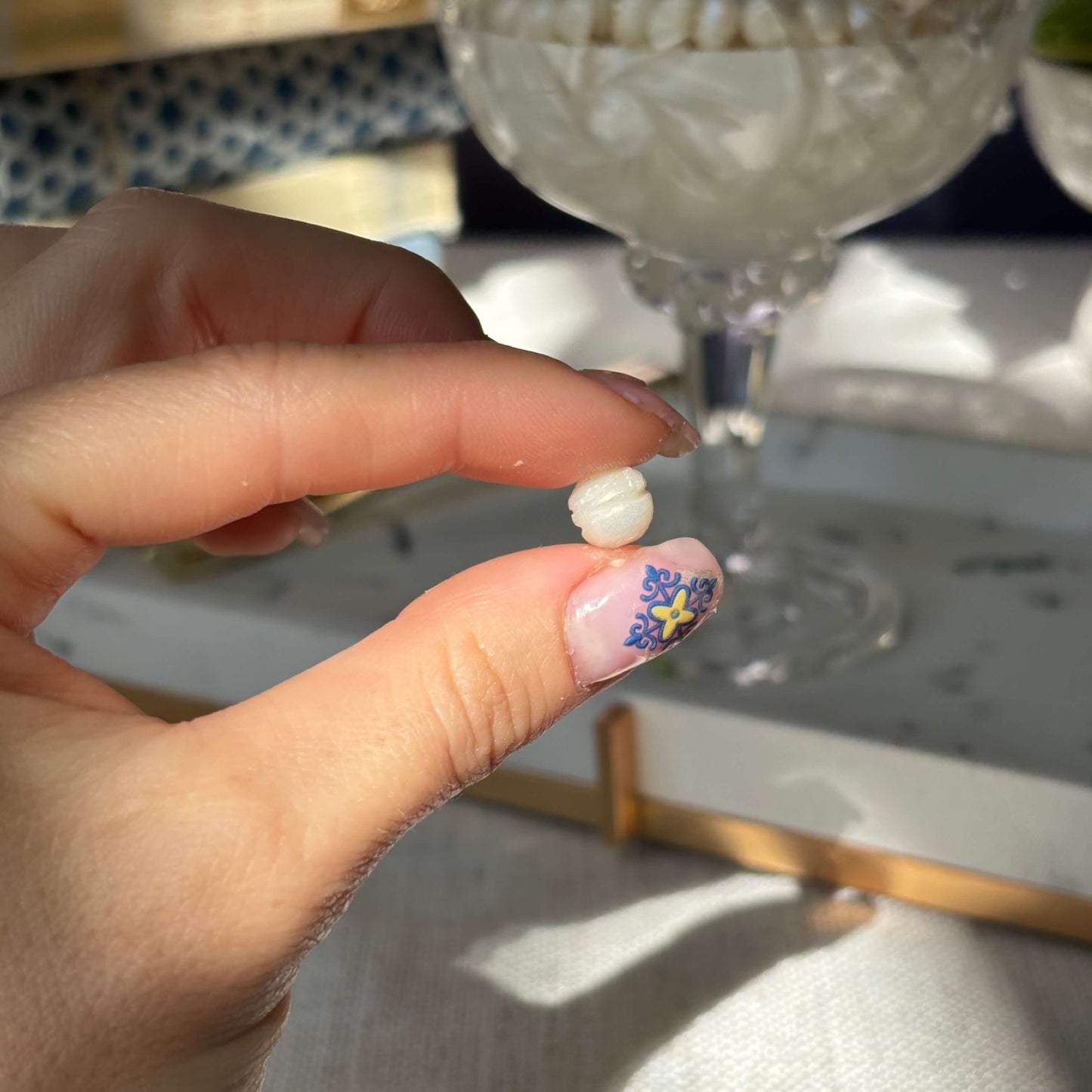 Close-up of handmade wax pearl held in hand — detail of luxury soy wax candle design