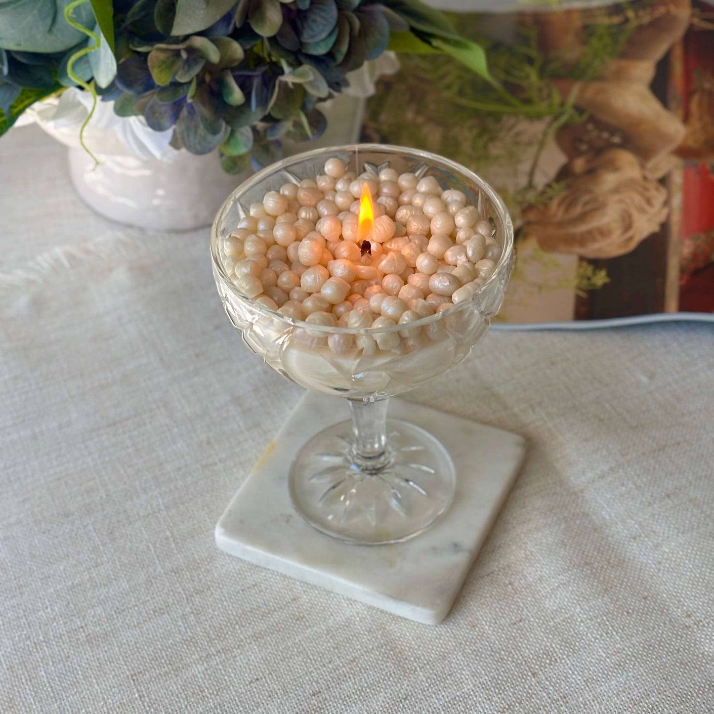 Lit pearl soy wax candle on a marble coaster — cozy coffee table decor and Thanksgiving gift idea