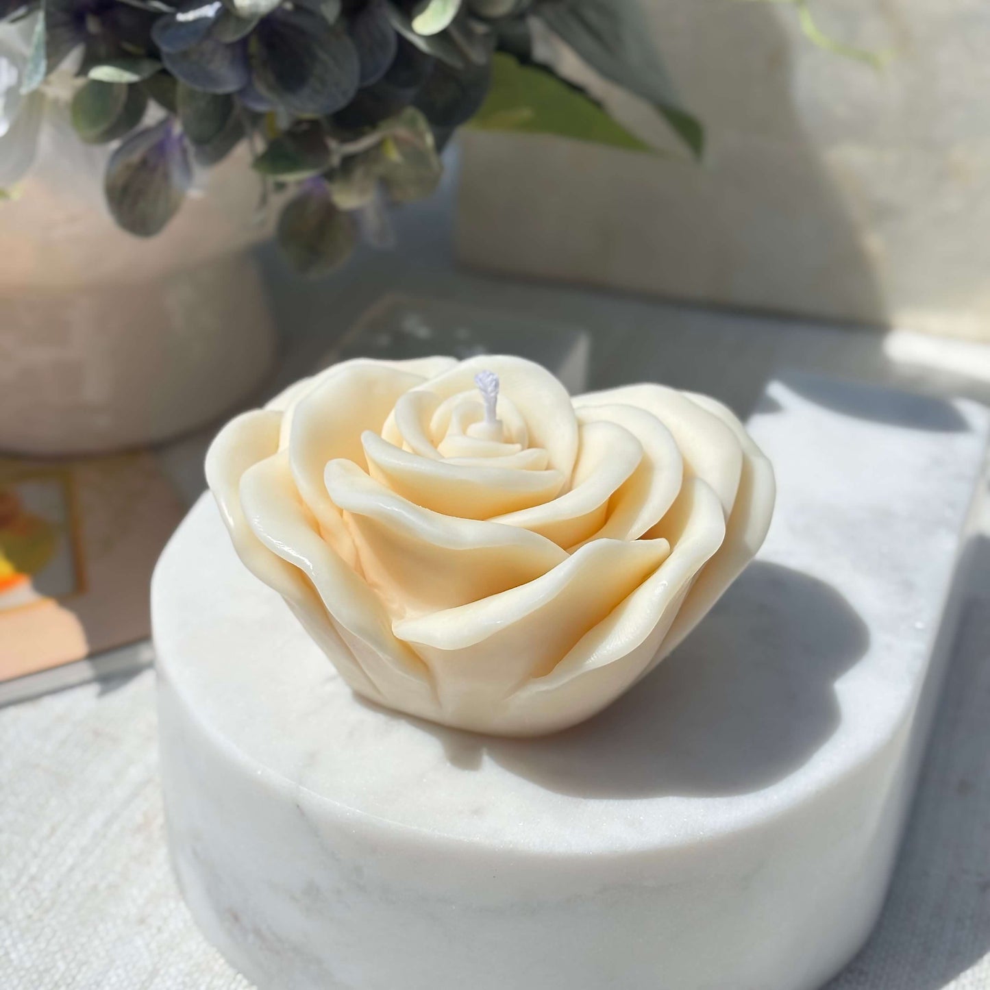 Cream rose shaped soy wax candle displayed on white marble base for home decor and gifting
