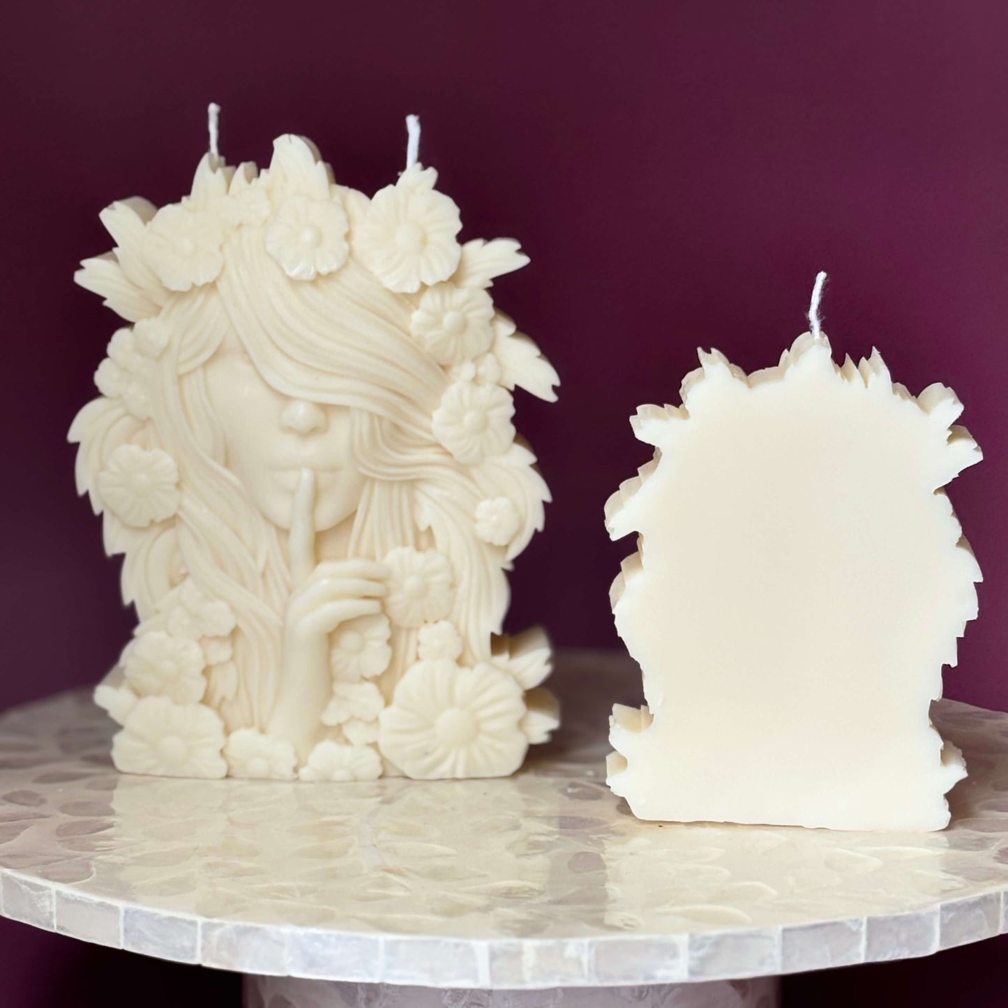 Back view of sculpted goddess candles showing wax texture and shape