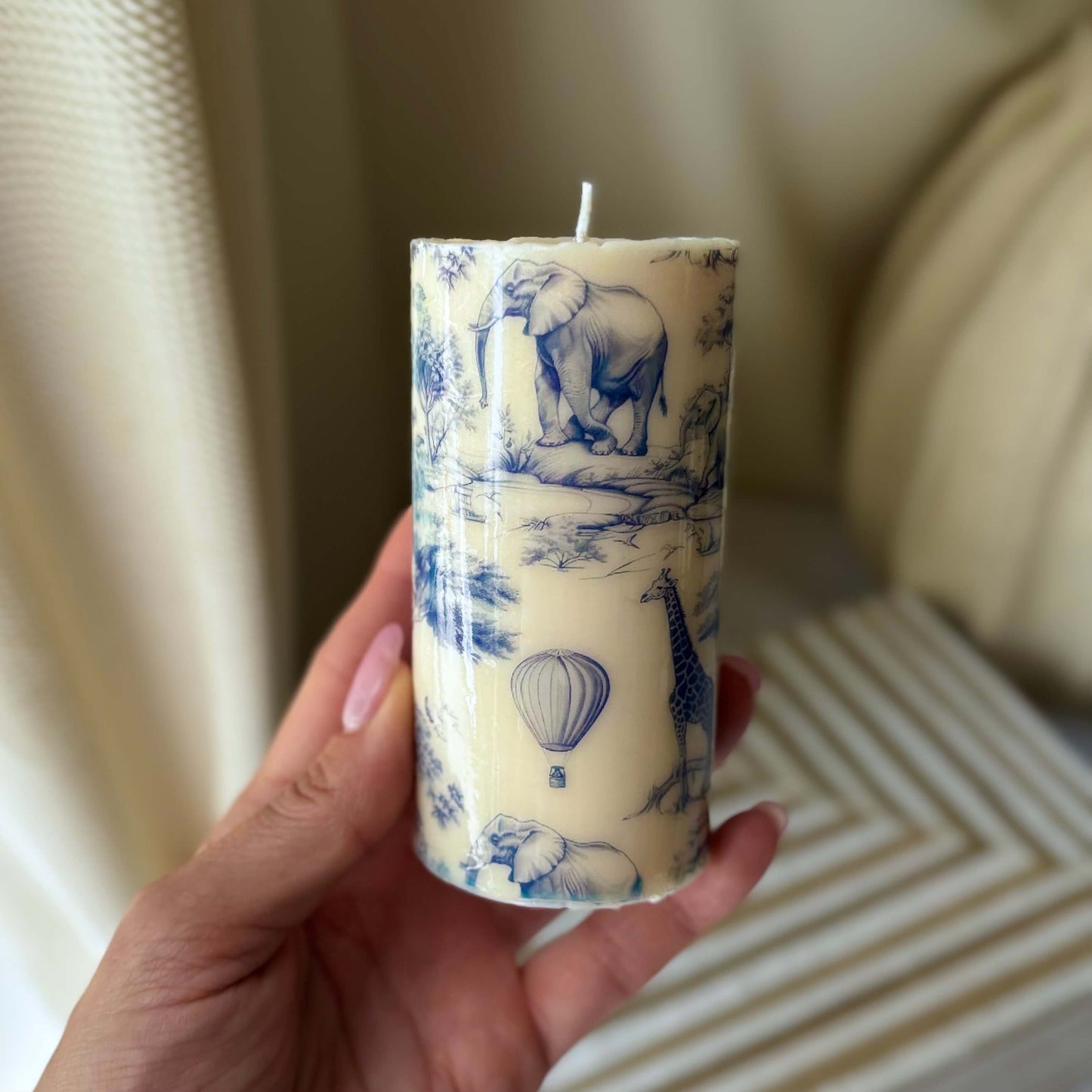 Artisan soy candle with blue and white Toile de Jouy print shown in hand, highlighting its size, design, and perfect gift appeal.