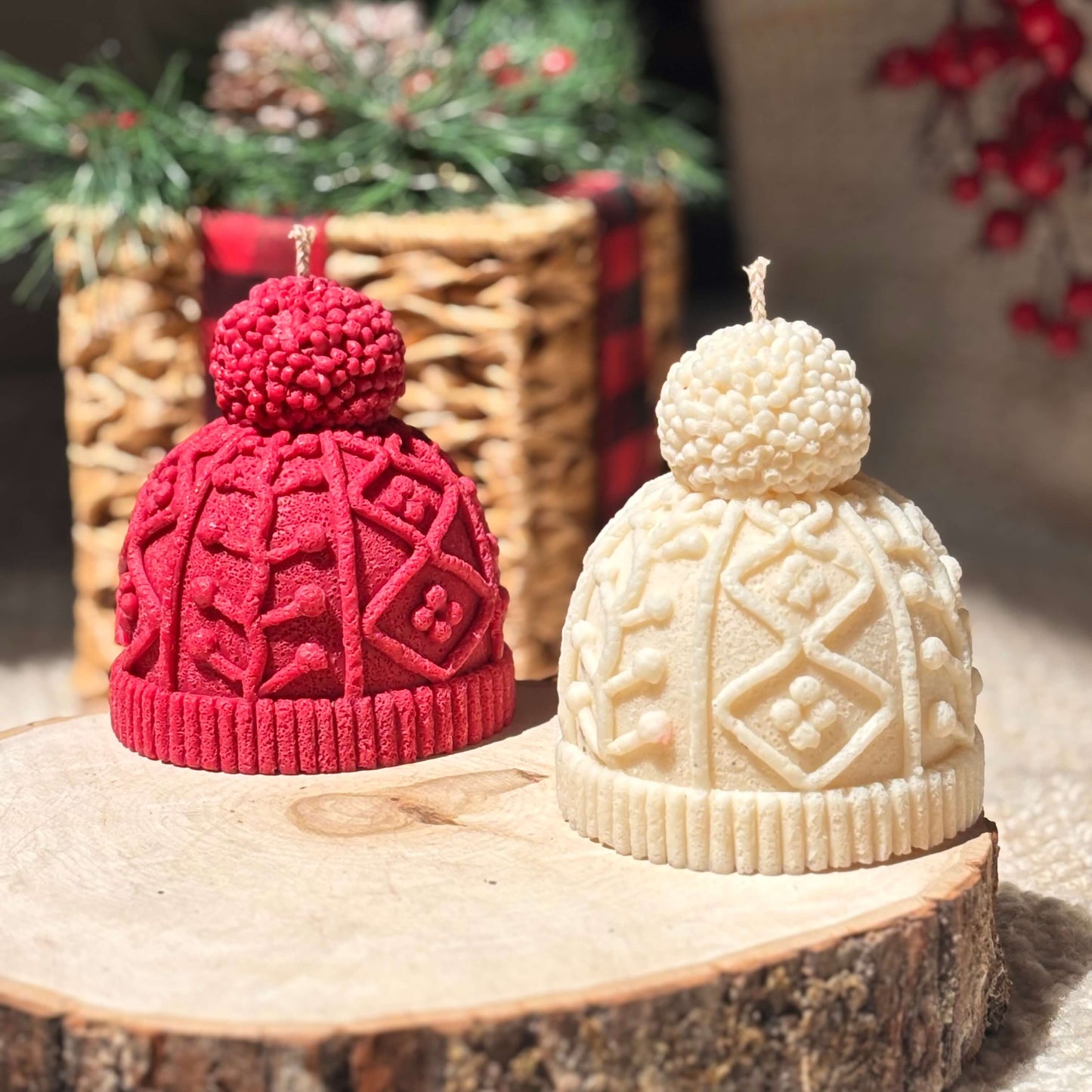 Textured winter candles in red and white shown outdoors on a wood slice with holiday greenery, perfect for natural Christmas styling and winter gifts