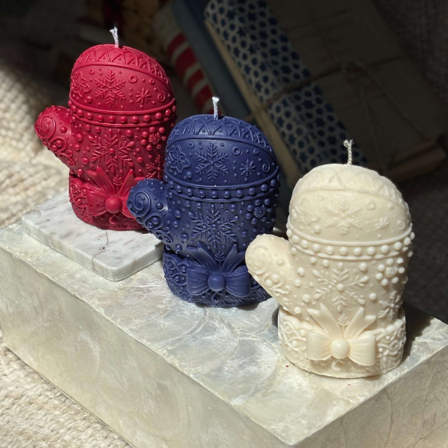 Trio of mitten candles in red, blue, and ivory — handcrafted soy wax with premium oils, perfect for Christmas decor and seasonal home accents.