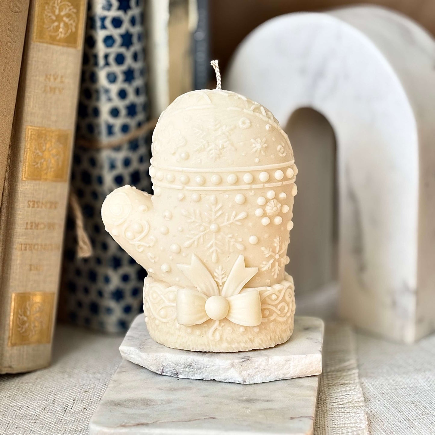 Elegant ivory mitten candle with snowflake relief and bow — handmade soy wax, premium fragrance oils, perfect Christmas or Thanksgiving gift.