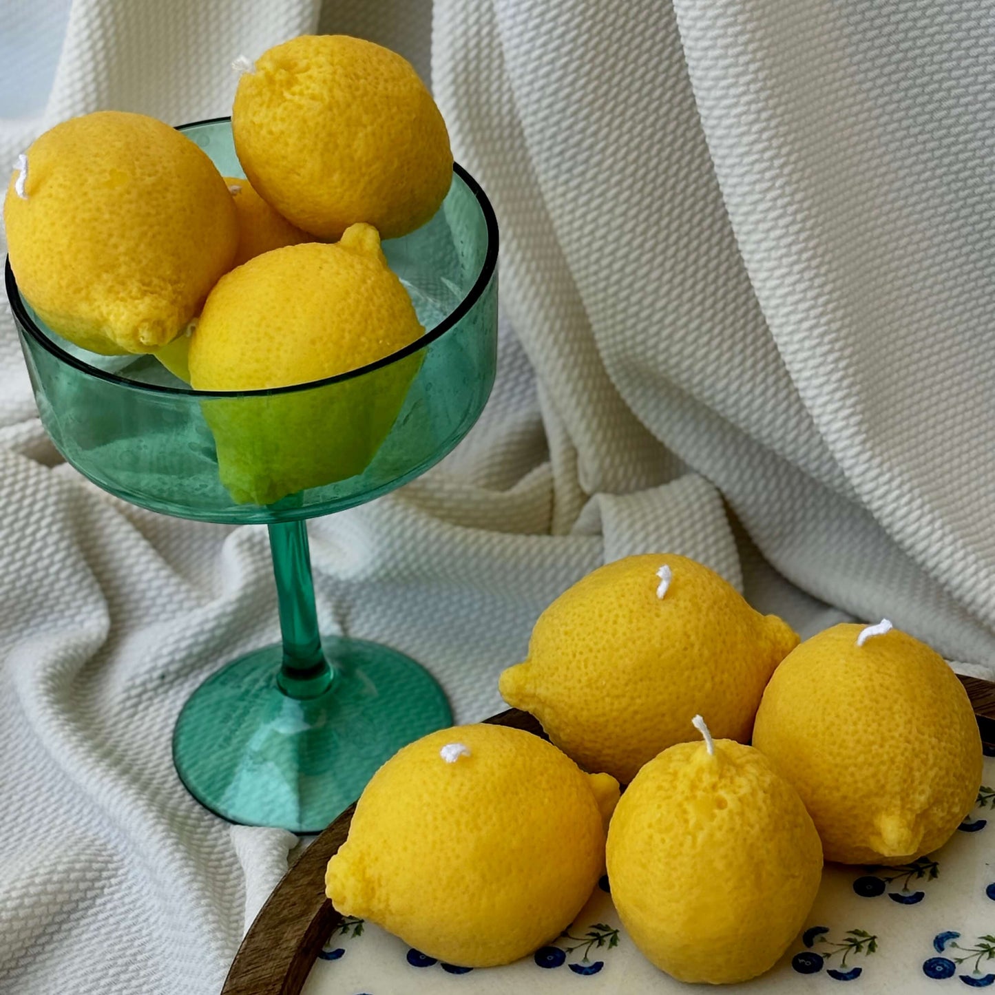 Lemon-shaped candles in a kraft gift box on home decor books. Unique eco-friendly citrus gift.