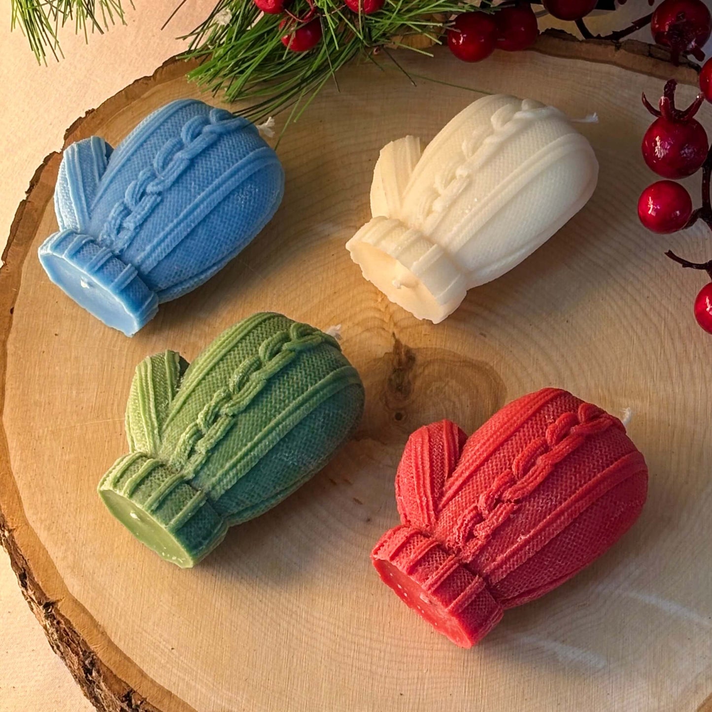 Colorful mitten-shaped candles on wood slice for Thanksgiving table or cozy holiday decoration