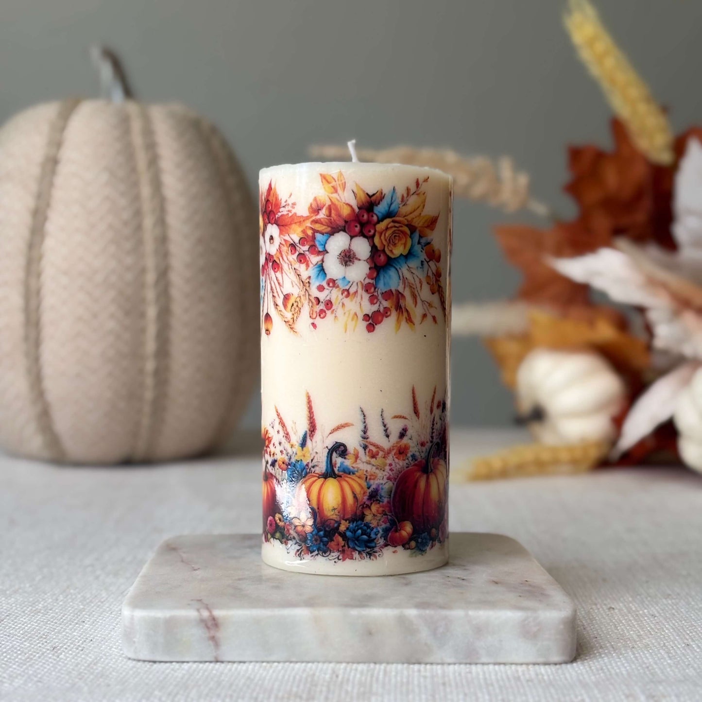 Seasonal pumpkin holiday candle with autumn harvest flowers, perfect handmade fall décor, Thanksgiving table centerpiece, and holiday gift idea.
