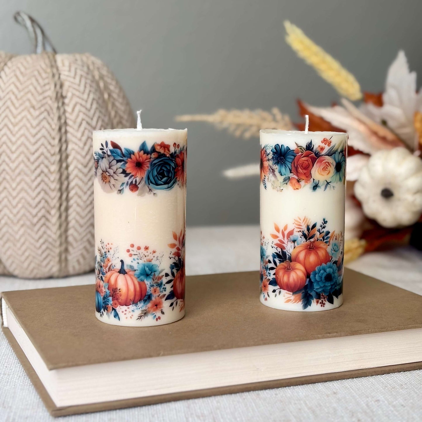 Two shiny pumpkin candles with floral patterns for fall home decoration