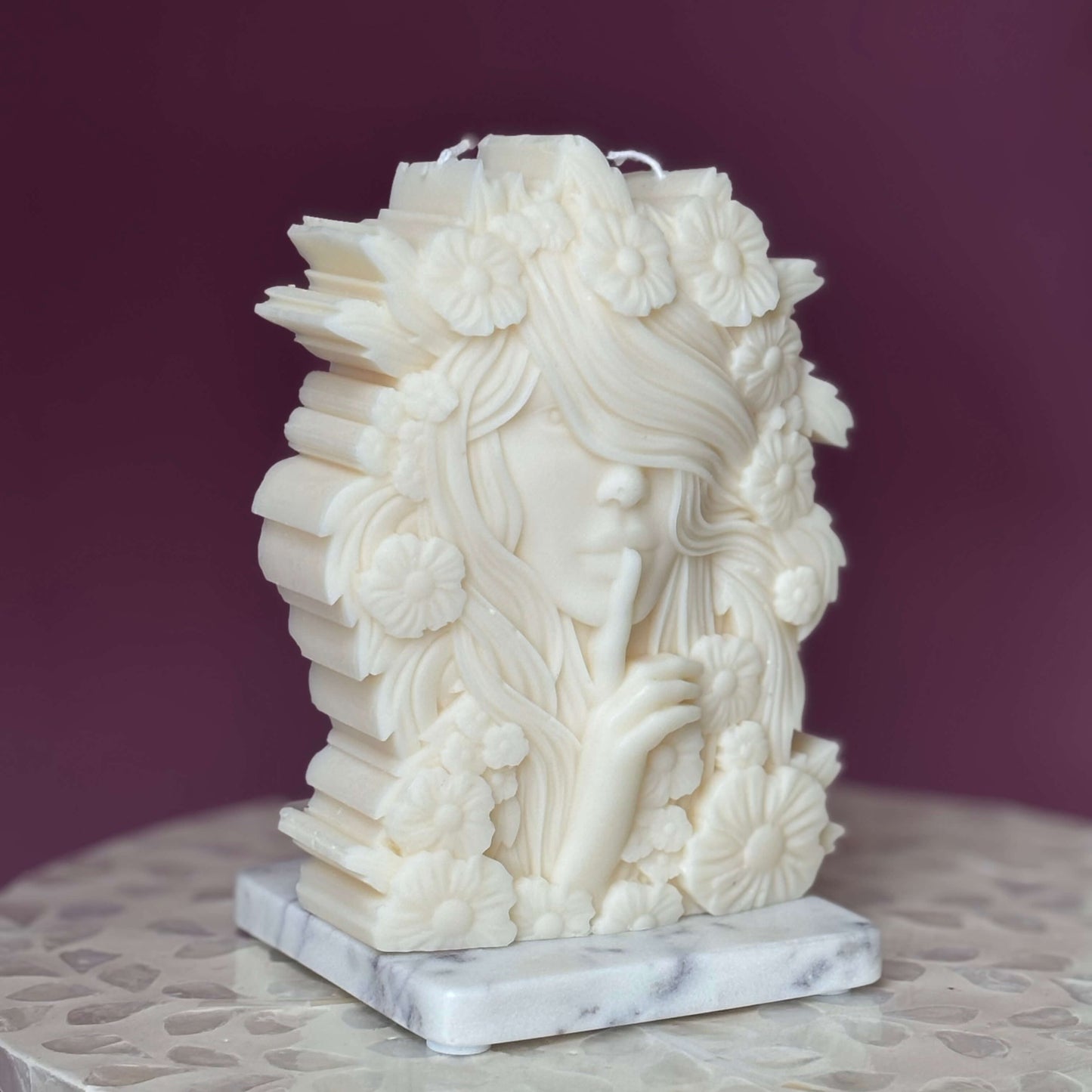 Side profile of floral goddess candle with sculpted flowers in hair