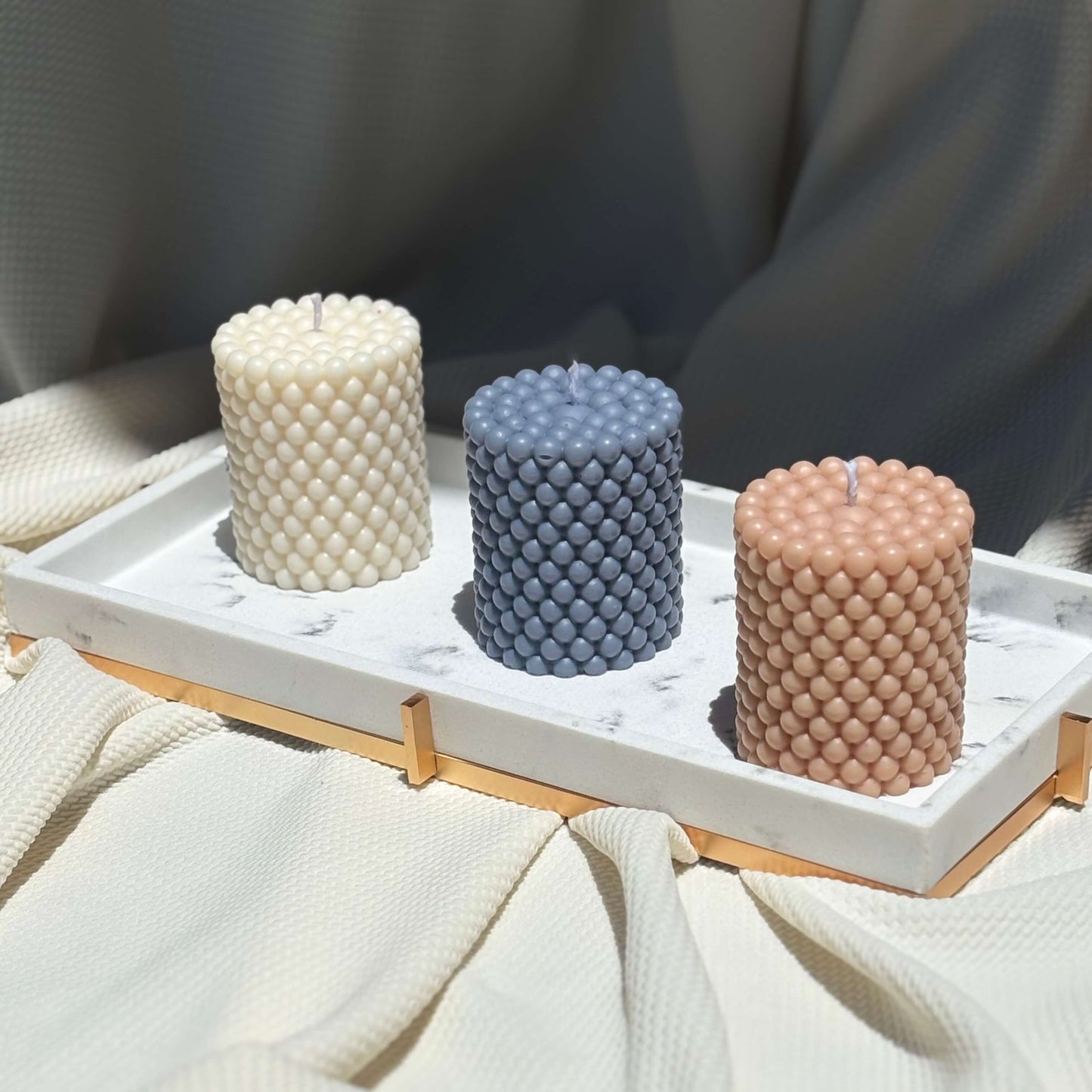 Textured wax candles arranged in gift tray — eco-friendly soy wax with artisan feel for relaxing home decor.
