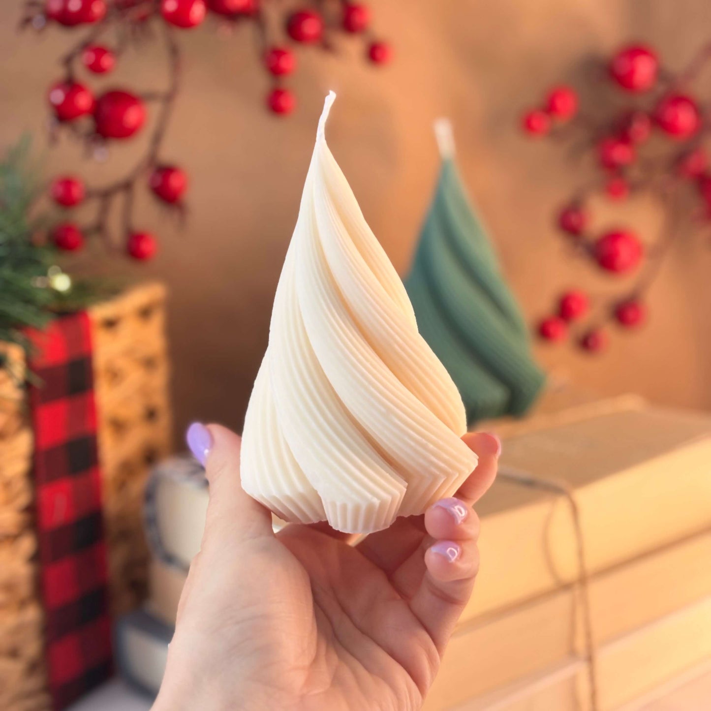 Cream twisted tree candle held in hand, ideal as Thanksgiving gift or Secret Santa present, cozy table decor with festive red berry background