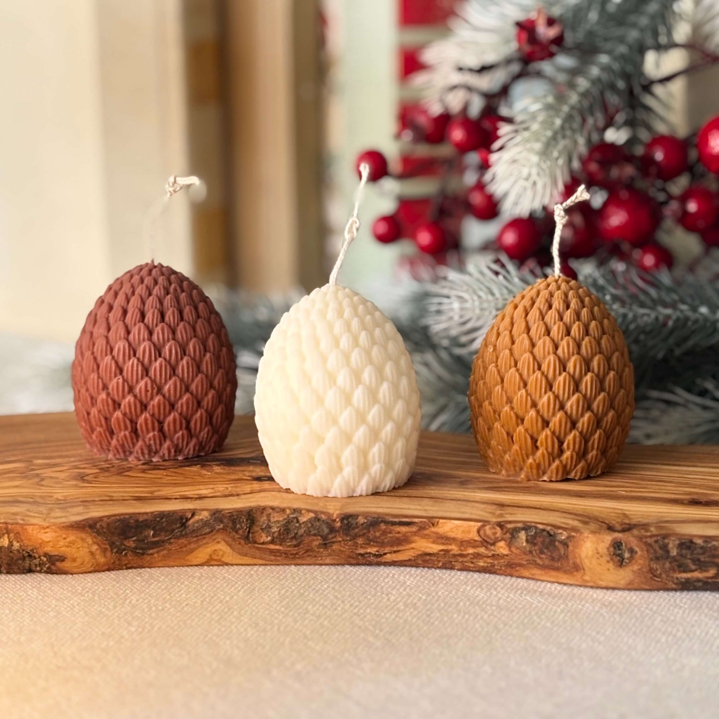 Decorative white textured soy candle in pinecone shape for winter holiday table setting