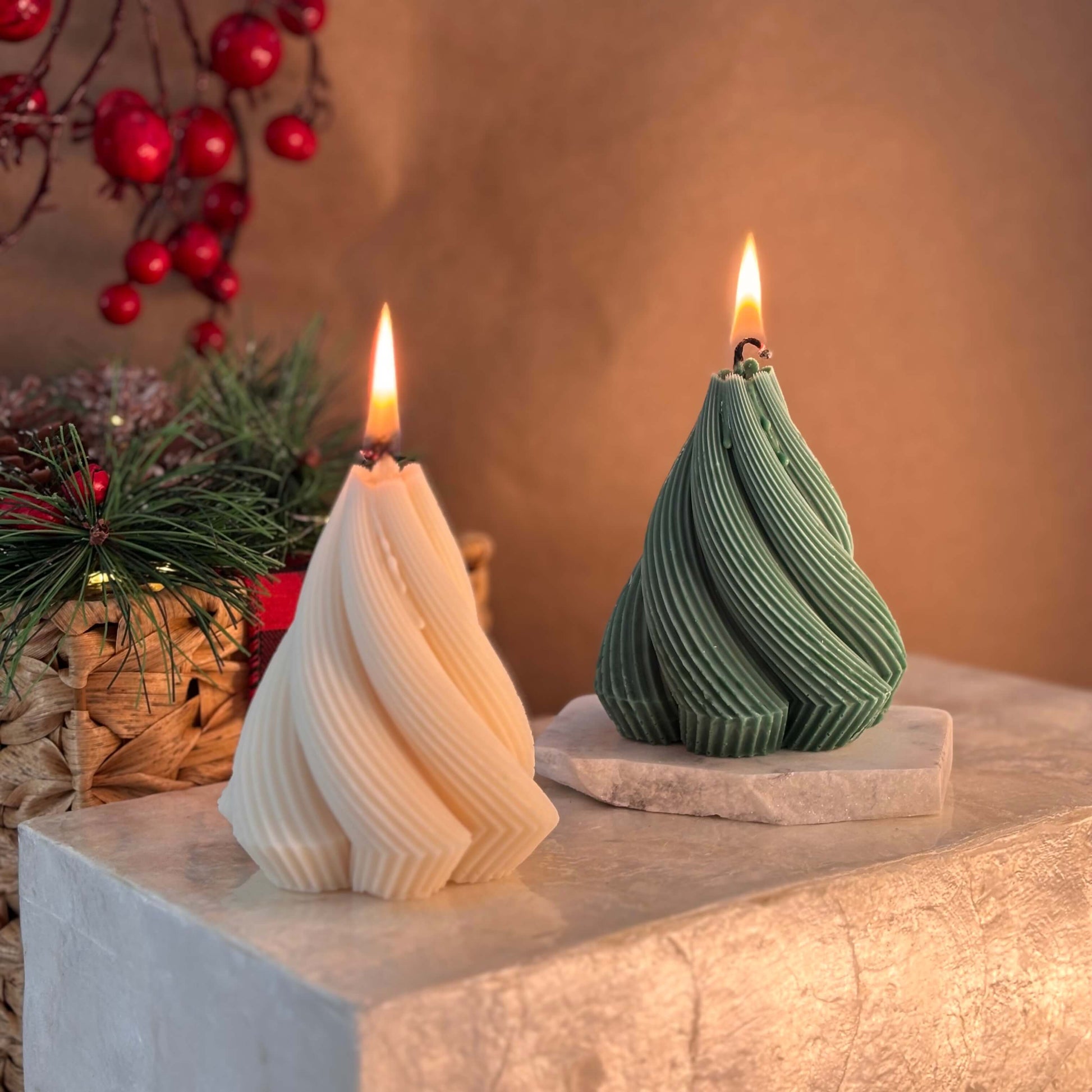 Two twisted Christmas tree-shaped soy candles in ivory and green colors with festive background and holiday decor

