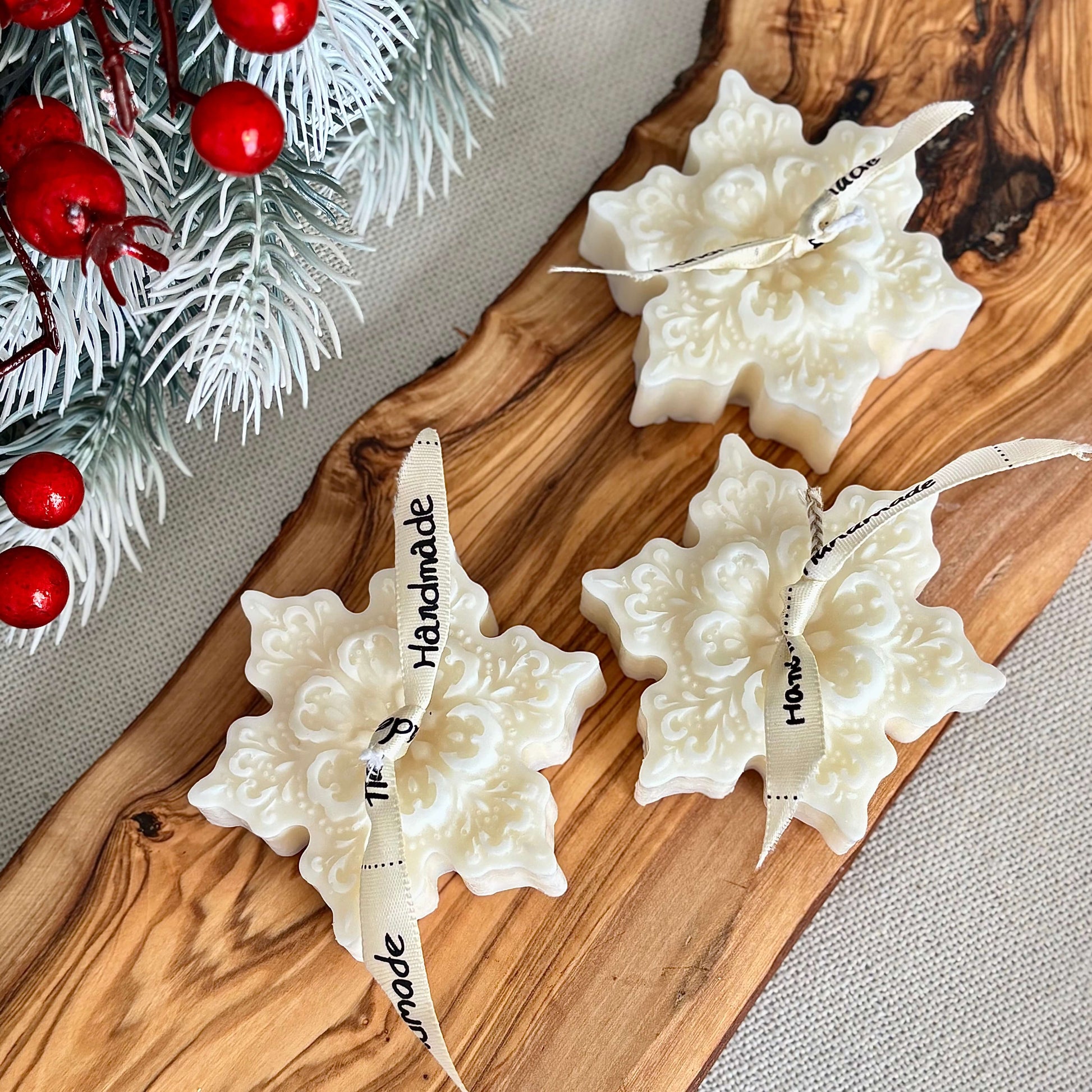 Winter snowflake shaped candles in natural soy wax with festive greenery background