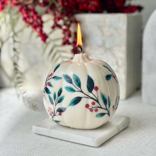 Lit pumpkin-shaped soy candle with floral and berry design on a marble coaster, perfect for Halloween, Thanksgiving, Christmas, birthday or fall home decor


