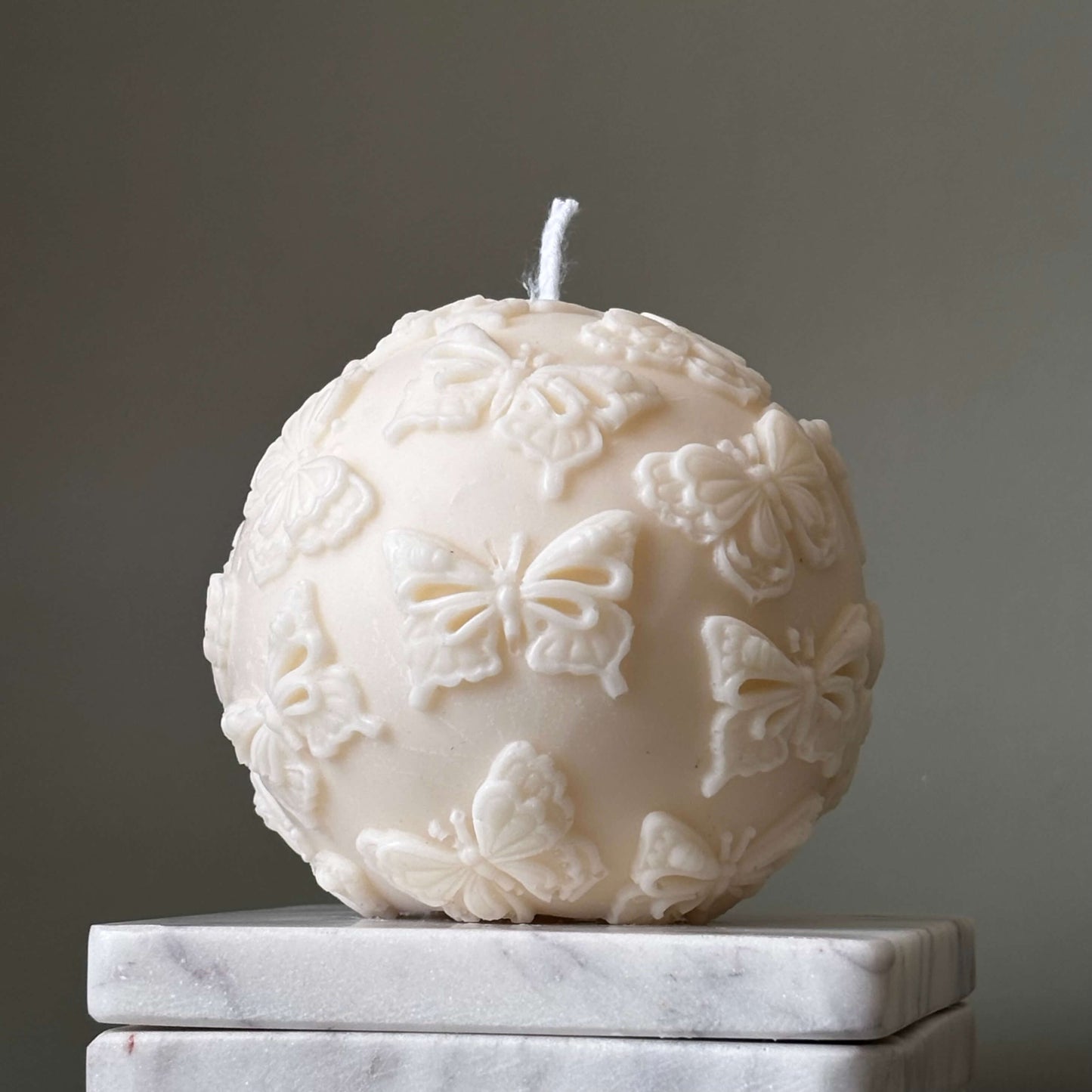 Aesthetic soy candle in round shape with butterfly accents
