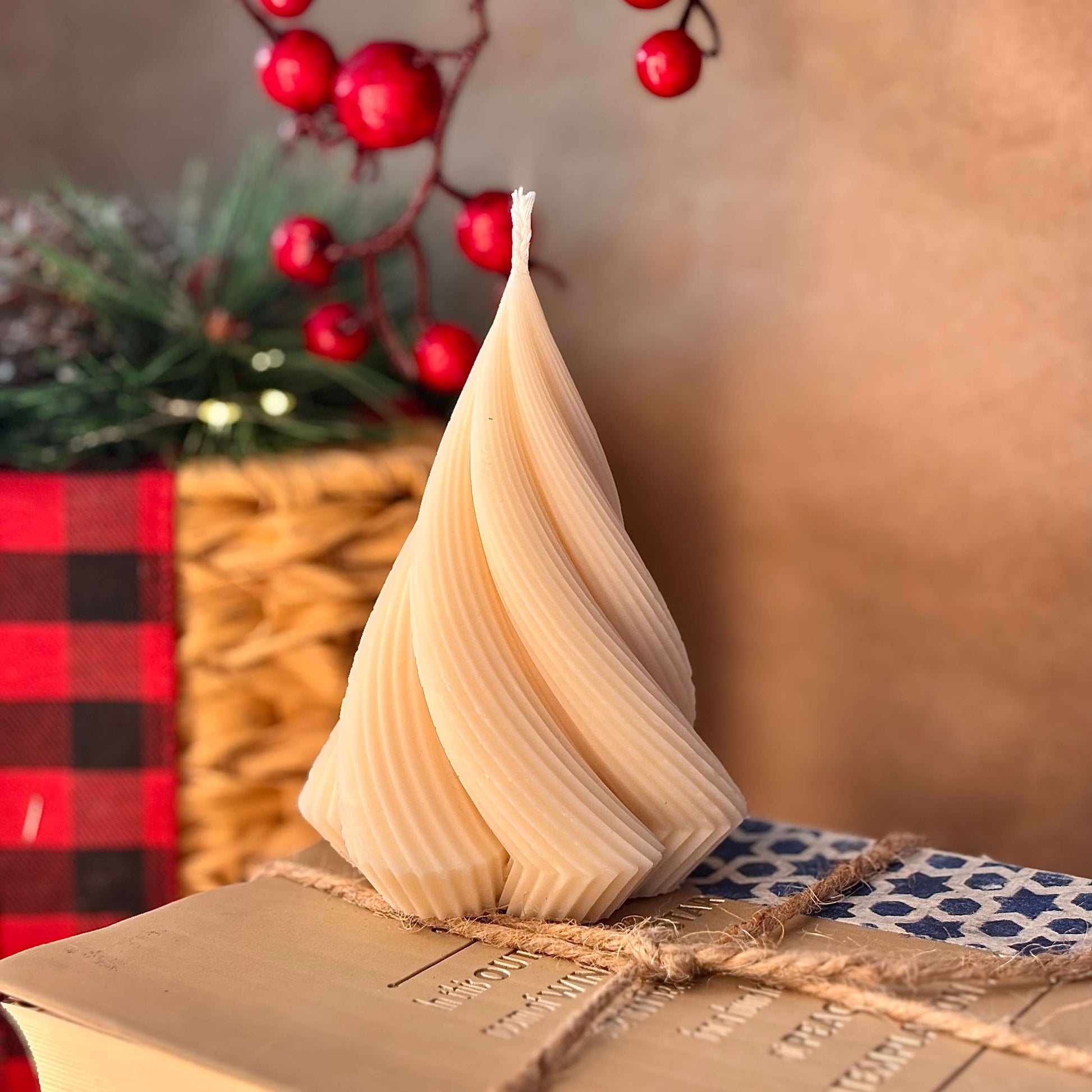 Beige spiral soy wax candle on twine-wrapped book, elegant table decoration or thoughtful gift for mom


