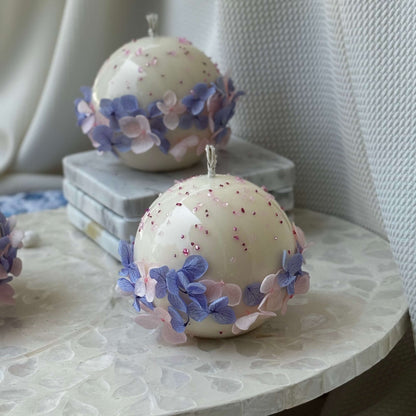 Pair of Bloomella round flower candles styled on mosaic side table for elegant home décor inspiration.	