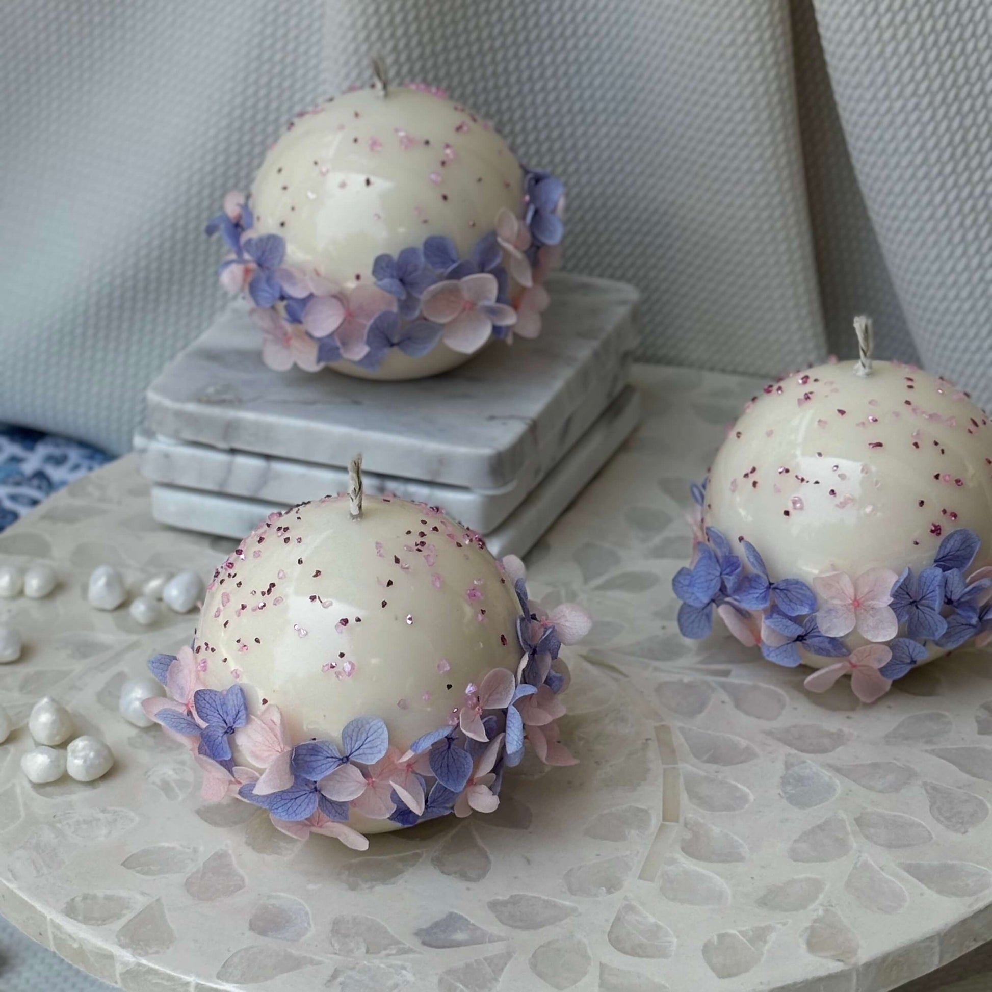 Elegant trio of handmade Bloomella soy candles on marble surface — perfect housewarming or bridesmaid gift.	
