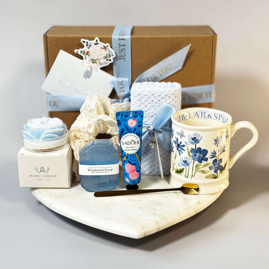 Luxury blue gift box with rose-shaped soy candle, floral mug, diamond soap, towel and hand cream – perfect self-care gift for her