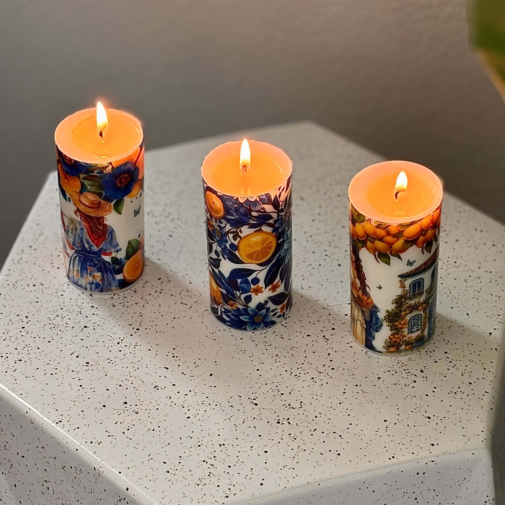 Lit Italian candles with D&G style lemon prints and floral Mediterranean design on white base

