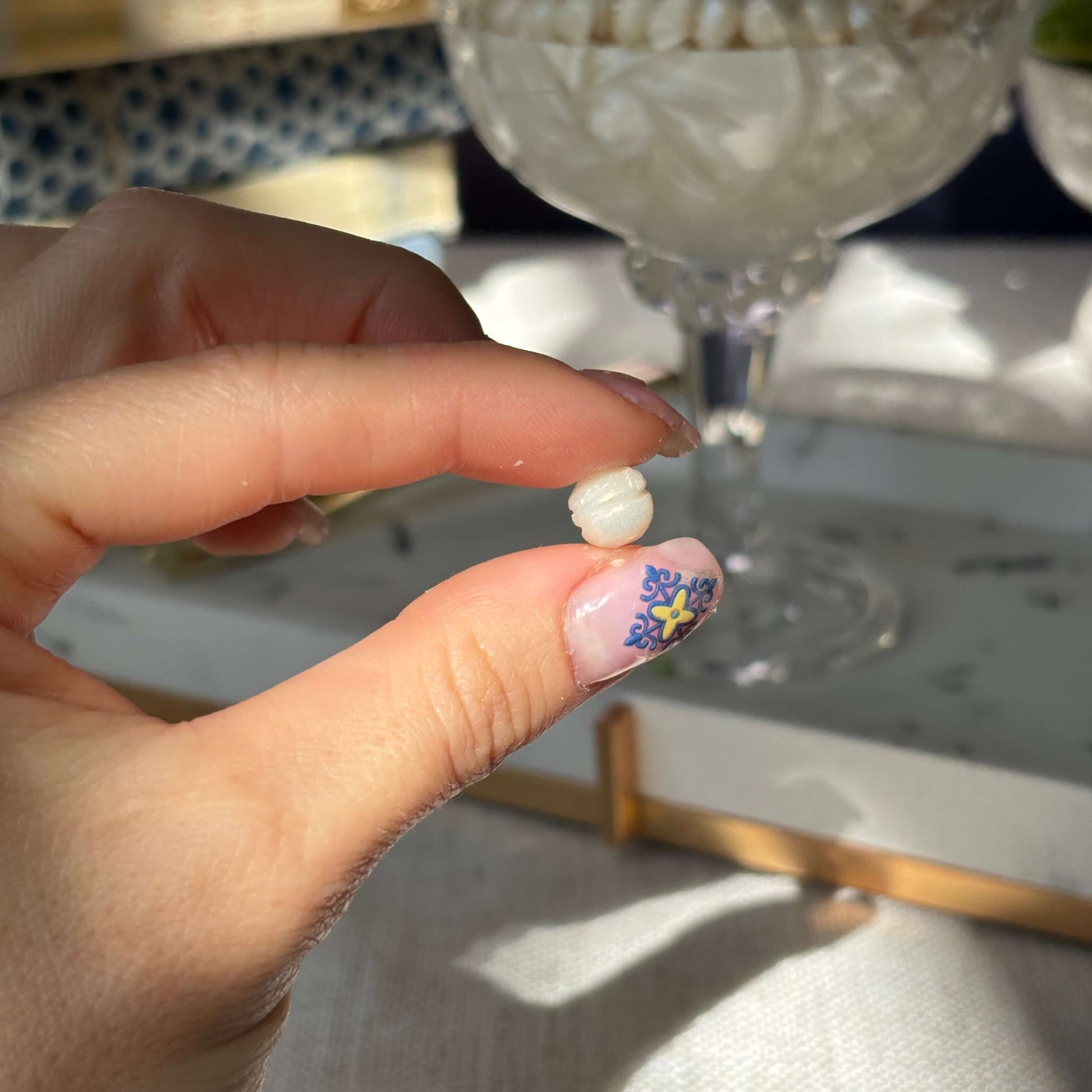 Close-up of handmade wax pearl held in hand — detail of luxury soy wax candle design

