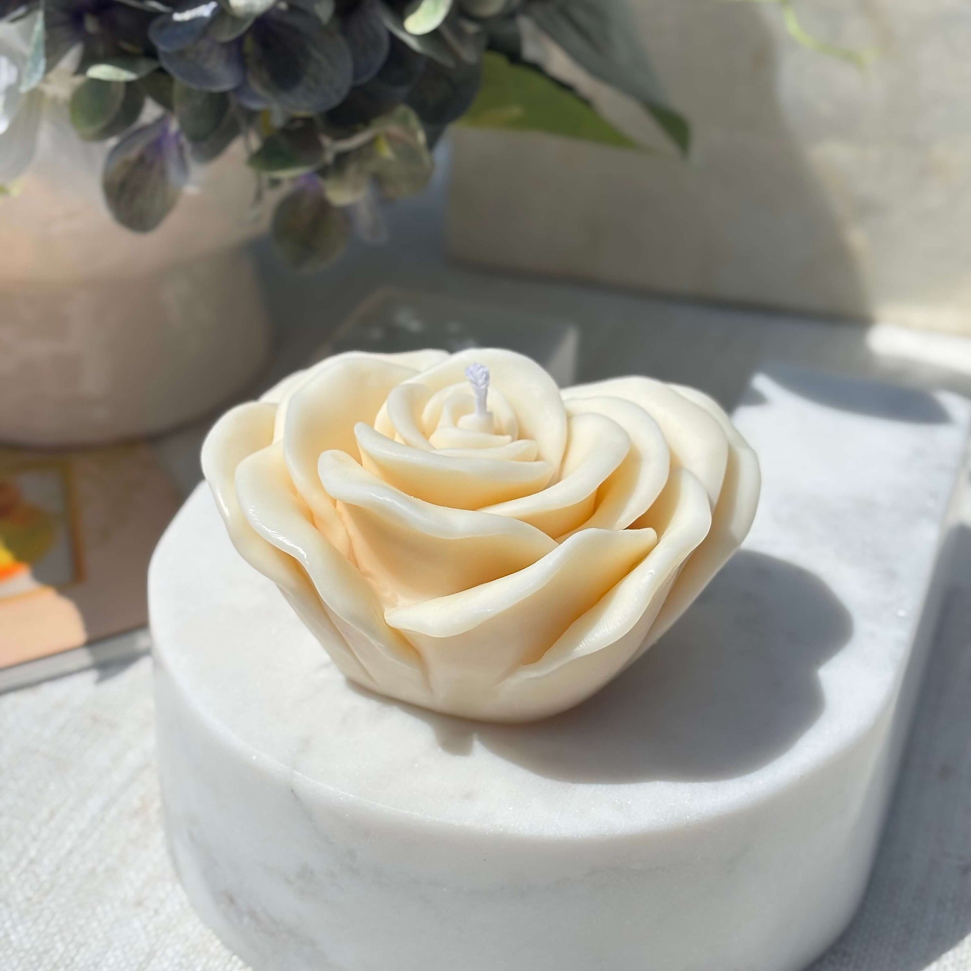 Cream rose shaped soy wax candle displayed on white marble base for home decor and gifting