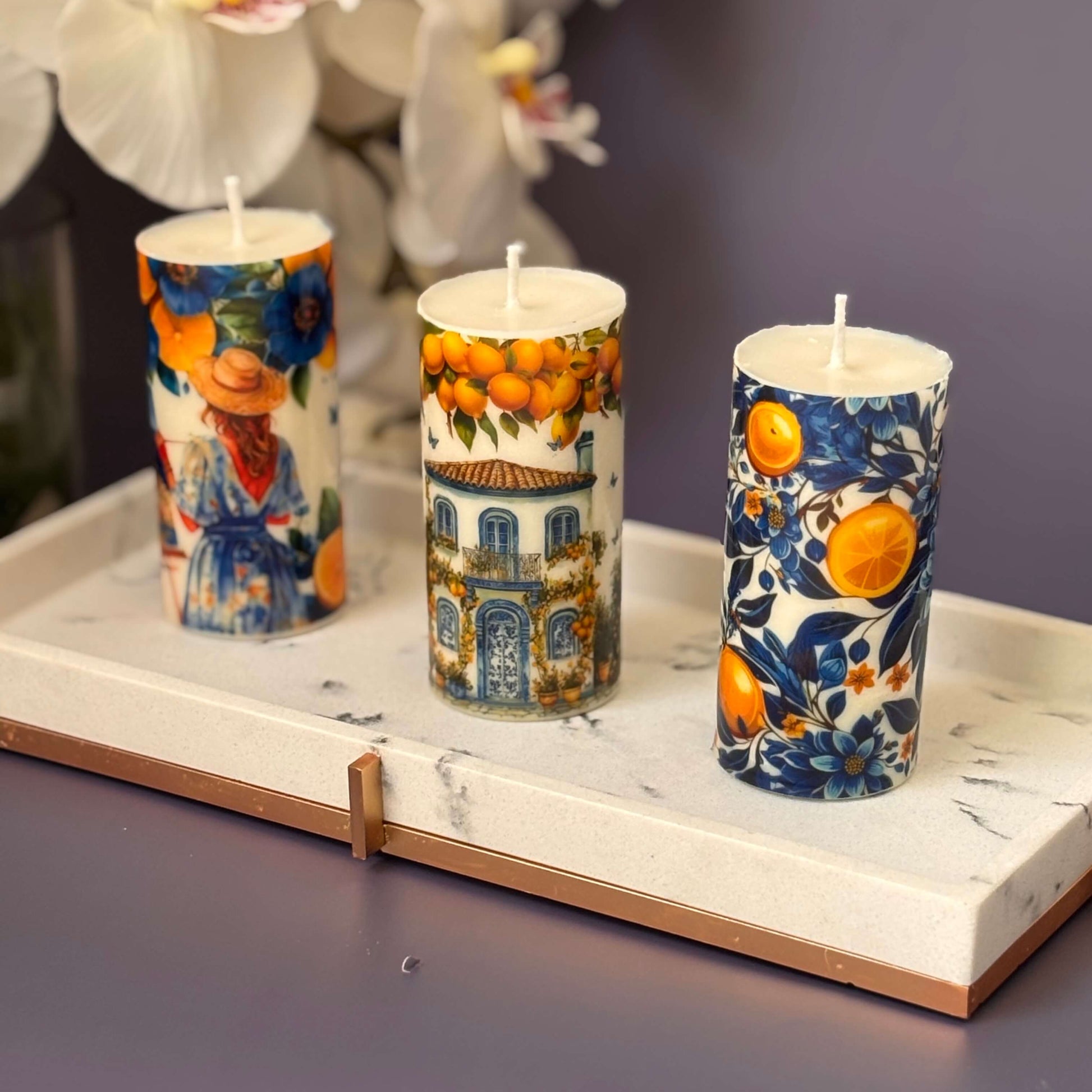 Decorative Italian-style soy candles with citrus patterns on a marble tray

