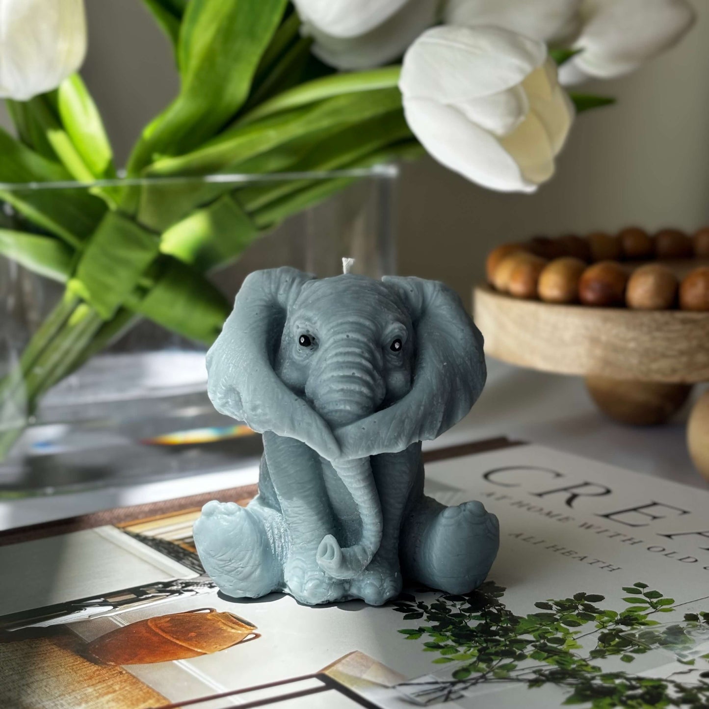 Elephant candle with paws covering eyes, handmade soy wax gift for animal lovers and cozy nursery decor.
