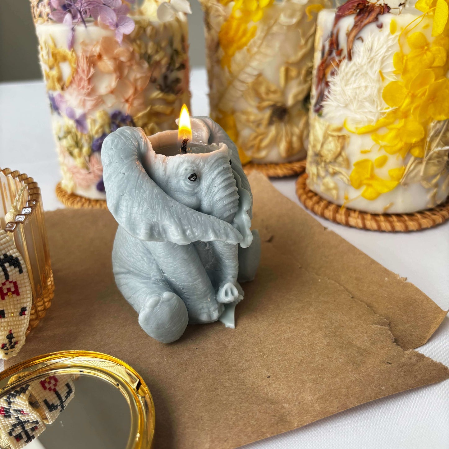 Lit elephant candle handmade from soy wax, whimsical sculptural candle for decor or thoughtful animal gift.
