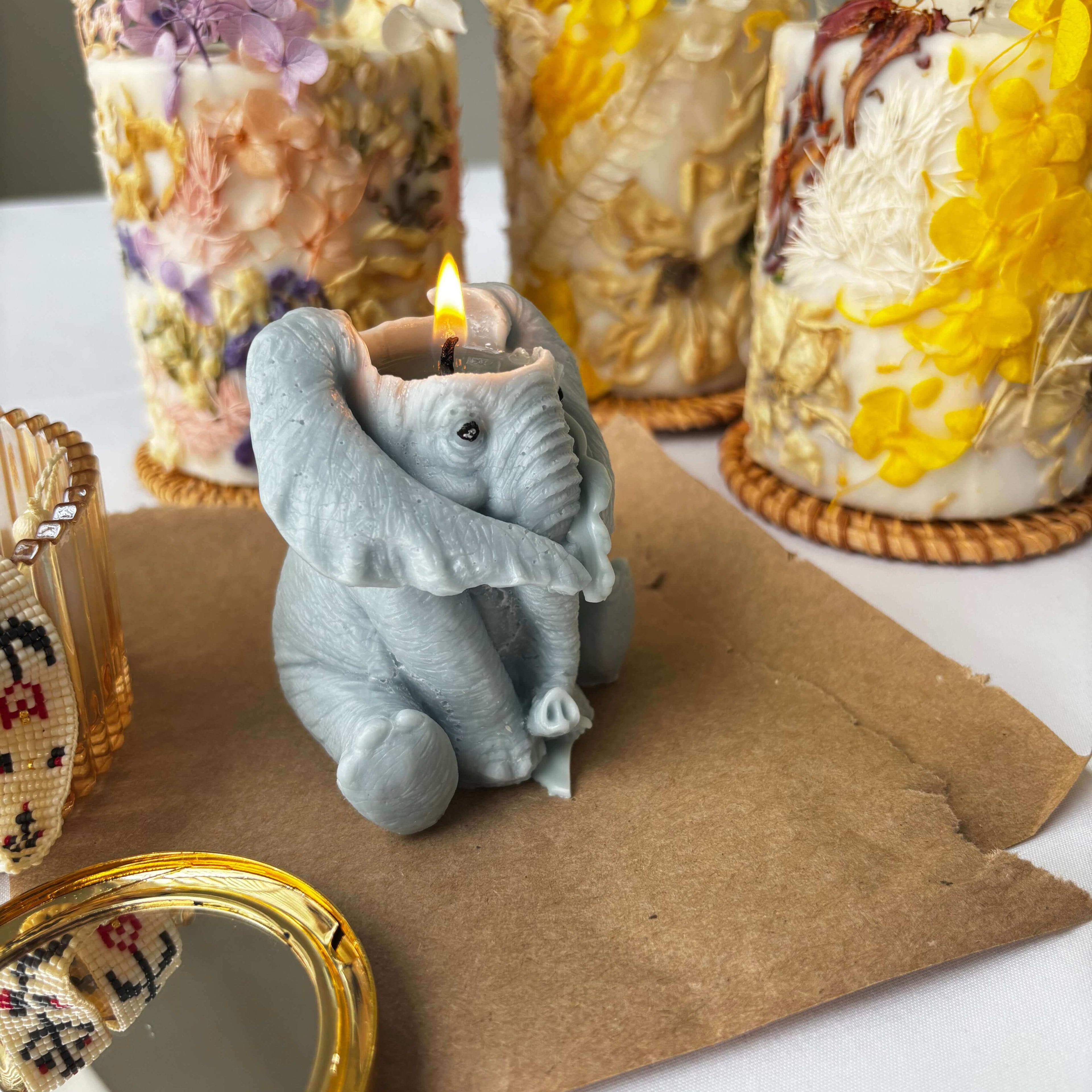 Lit elephant candle handmade from soy wax, whimsical sculptural candle for decor or thoughtful animal gift.
