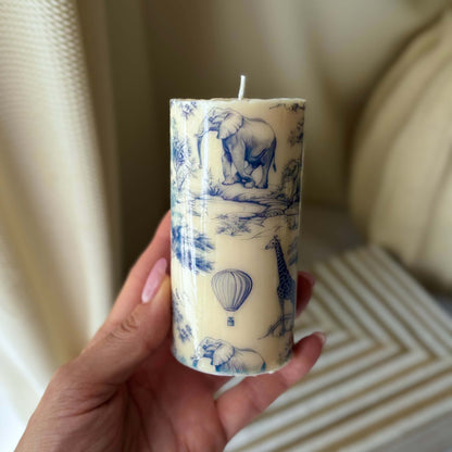 Artisan soy candle with blue and white Toile de Jouy print shown in hand, highlighting its size, design, and perfect gift appeal.