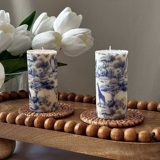 Handmade glossy pillar candle with blue Toile de Jouy design, brilliant shine finish, perfect for coffee table or Afro-inspired home décor.