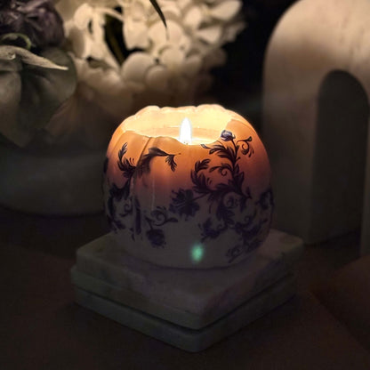  Glowing pumpkin candle with floral design, lit in a dim setting to create a warm ambiance — perfect for Halloween or romantic evenings. Glowing pumpkin candle with floral design, lit in a dim setting to create a warm ambiance — perfect for Halloween or romantic evenings.