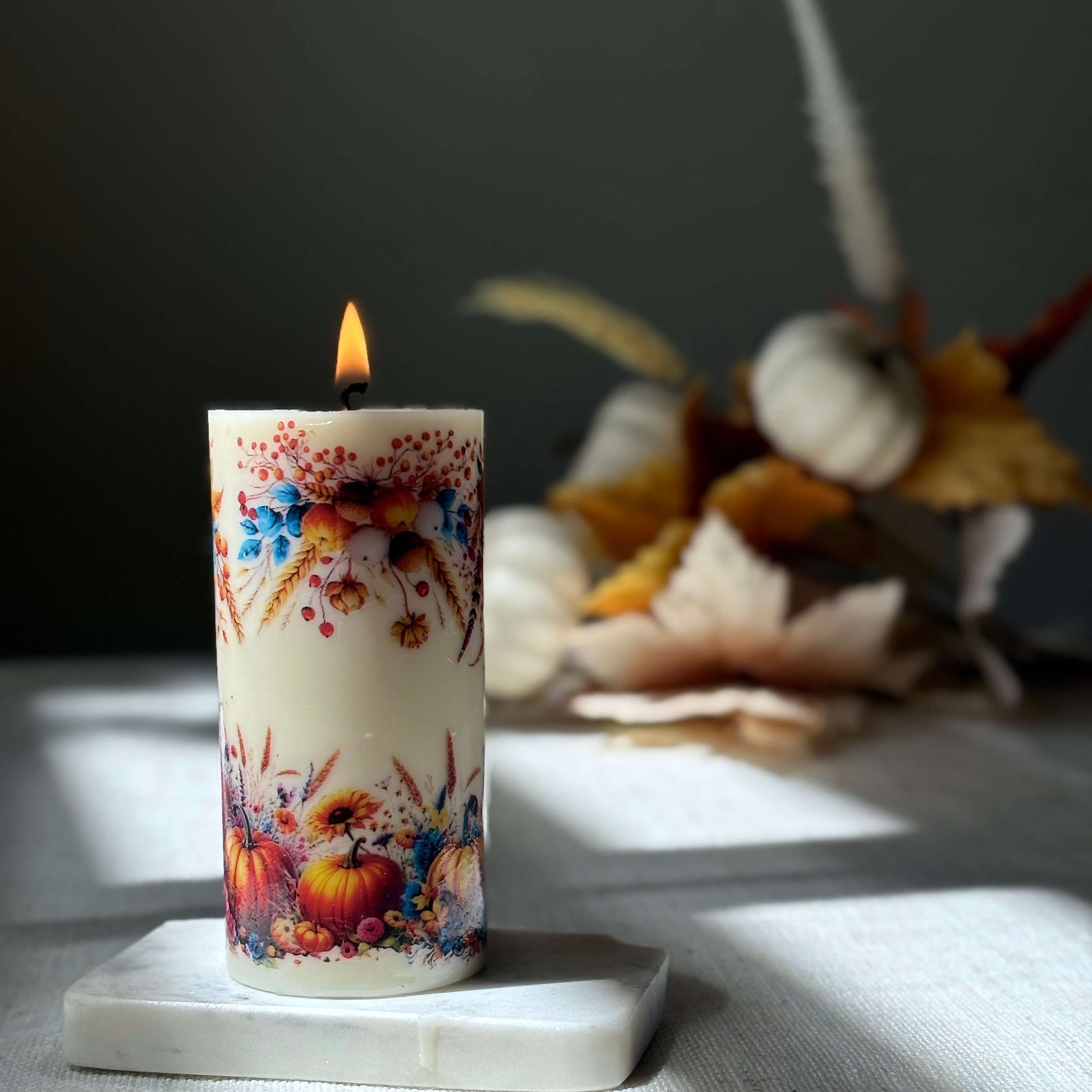 Glowing pumpkin holiday candle with autumn floral design, handmade seasonal decor piece for cozy fall evenings, Thanksgiving, and holiday décor.