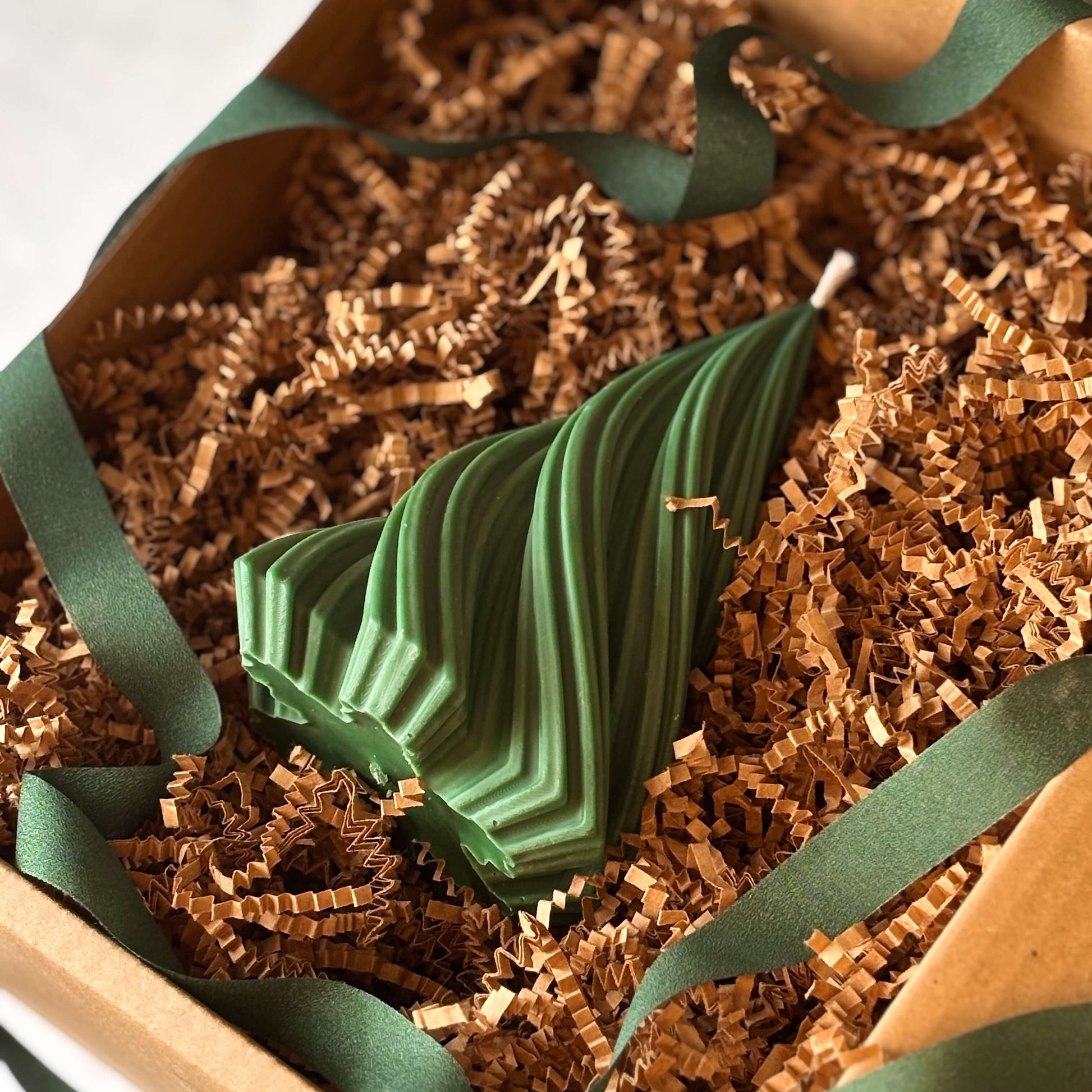 Handmade green Christmas tree candle in kraft gift box with ribbon and crinkle paper, ideal holiday gift for her.