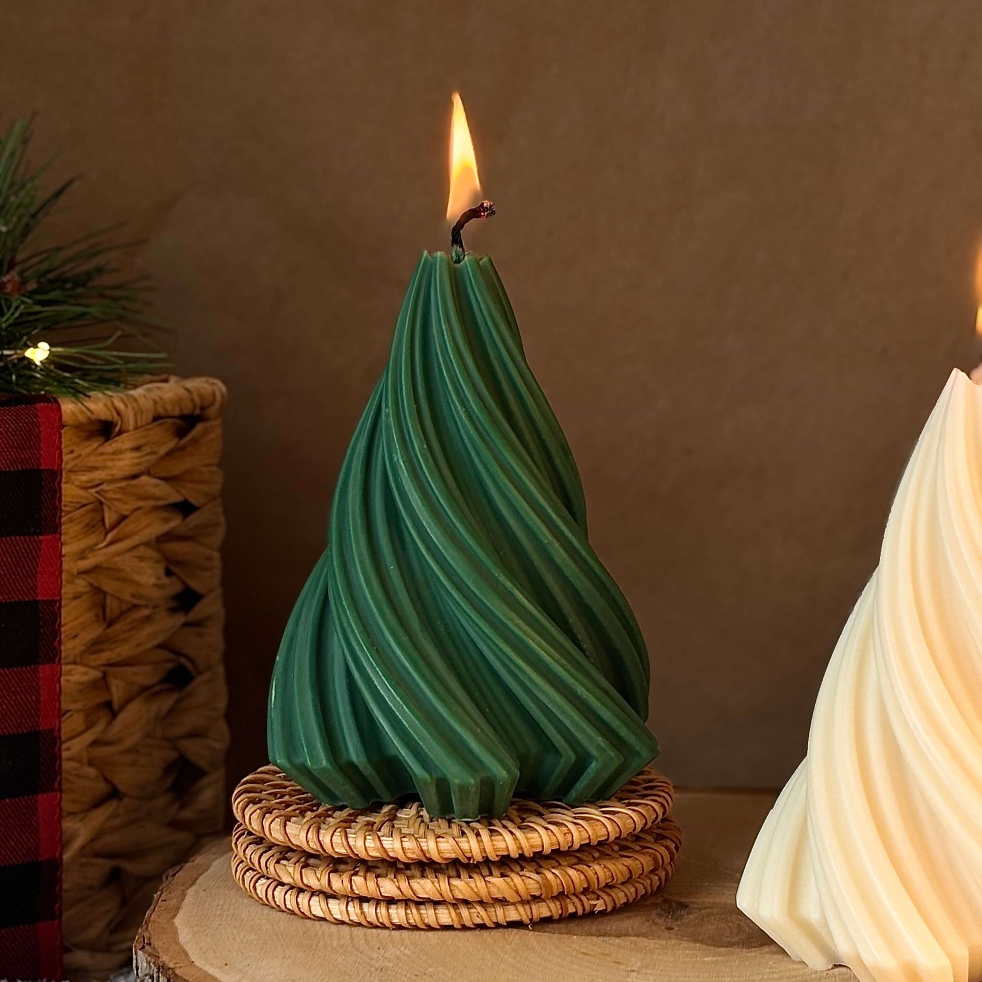 Close-up of green handmade Christmas tree candle on wicker stand, holiday aesthetic for festive table decor.