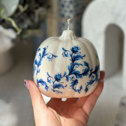 Unscented vintage-style pumpkin candle with glossy floral print, shown in hand to highlight size — perfect for gifting and home accents.