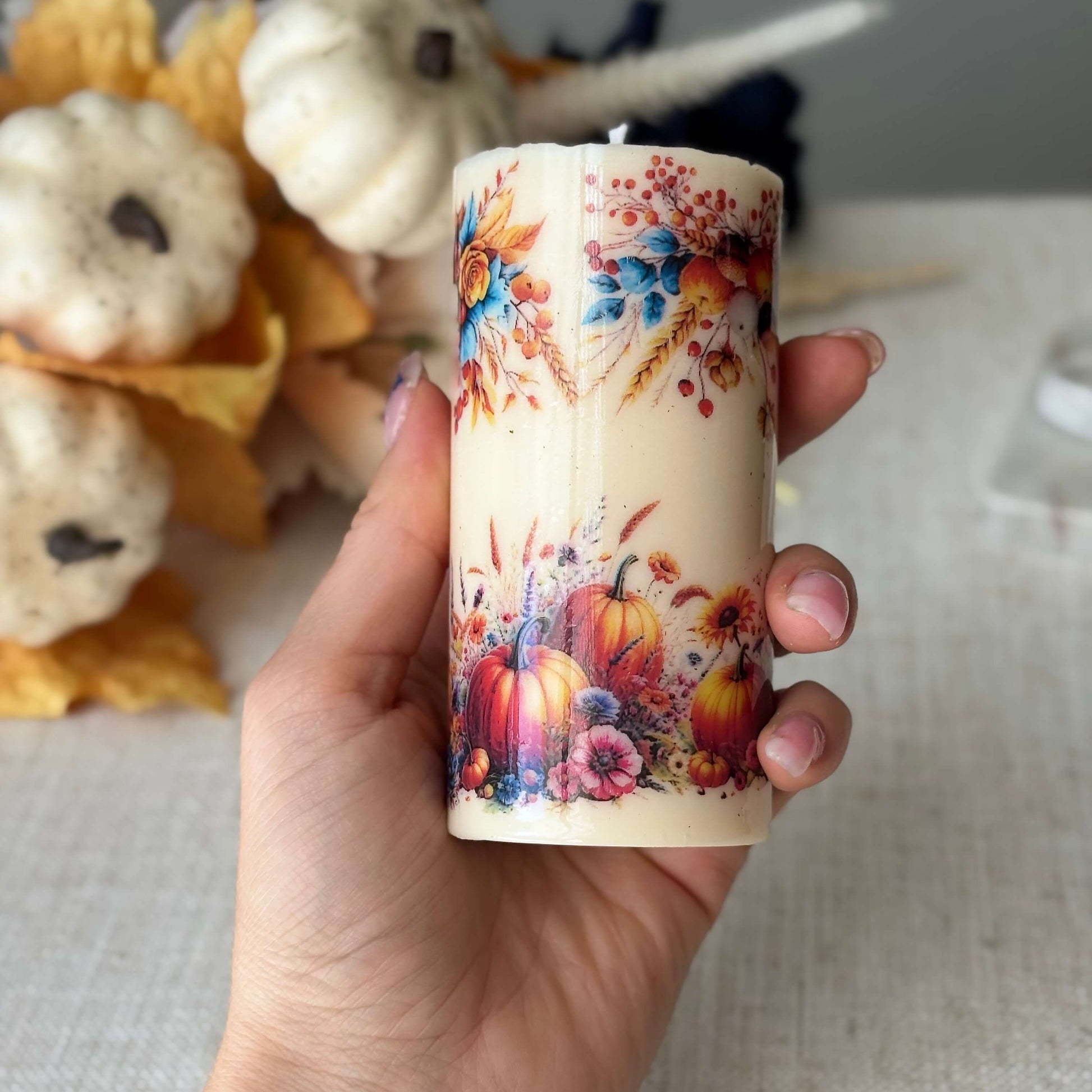 Handmade pumpkin holiday candle held in hand, autumn floral design, perfect for fall décor, Thanksgiving centerpiece, and cozy holiday accent.