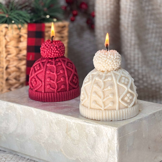 Red and white winter hat candles displayed on a stone base as elegant Christmas table decor and cozy holiday gift idea